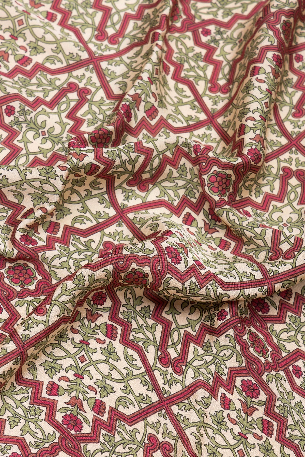 Close up of Beige Crepe Saree with Printed design on the body and Printed Border.  displaying folds
