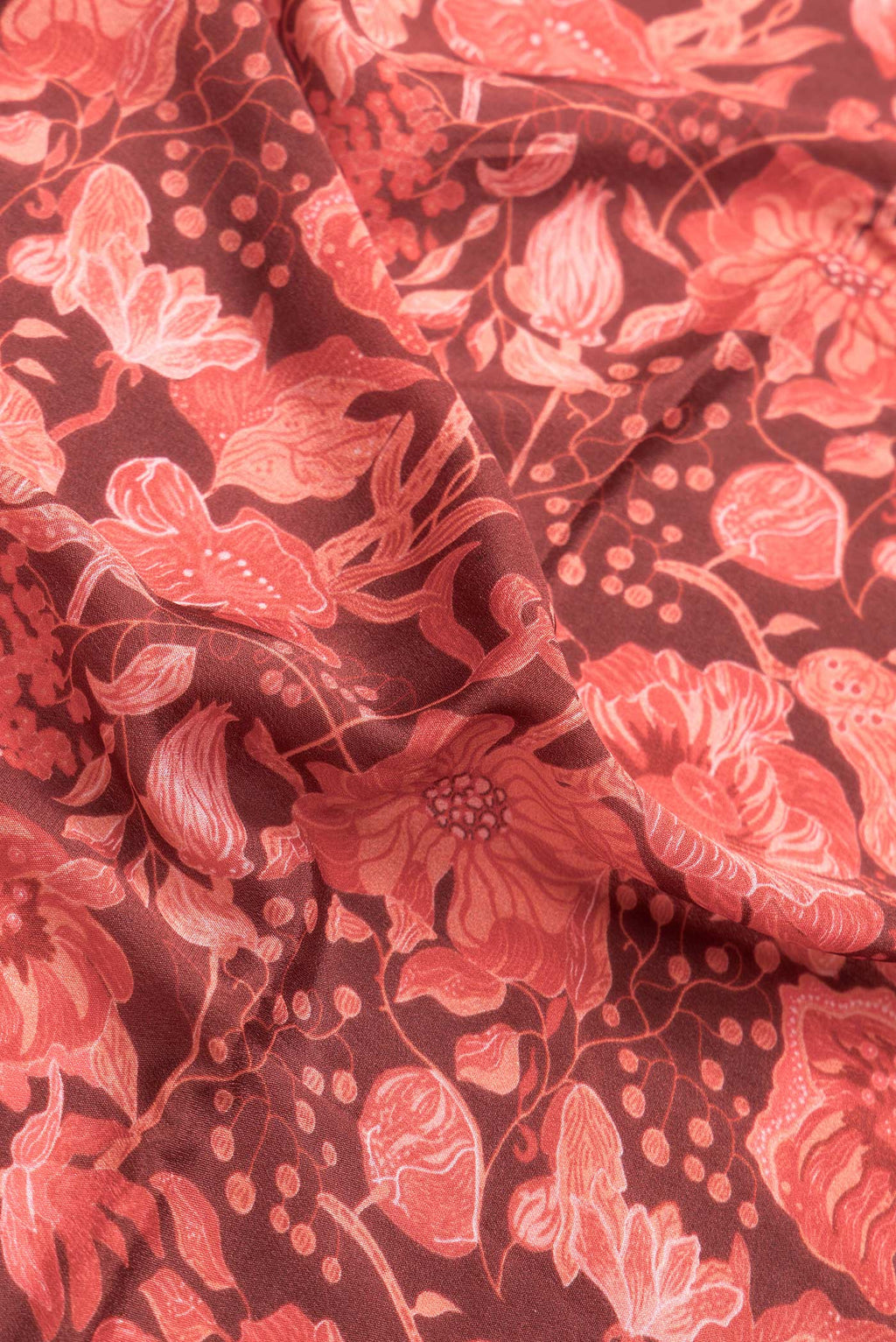Close up of Maroon Dual Tone Mysore Crepe Saree with Printed design on the body and Zari Border.  displaying folds