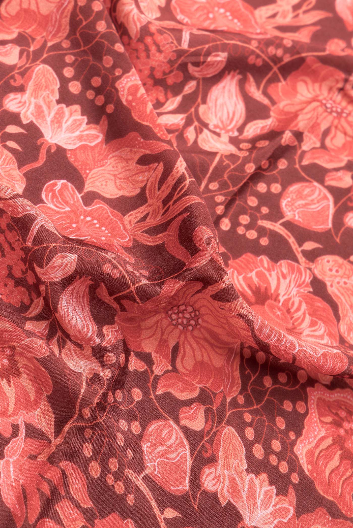 Close up of Maroon Dual Tone Mysore Crepe Saree with Printed design on the body and Zari Border.  displaying folds