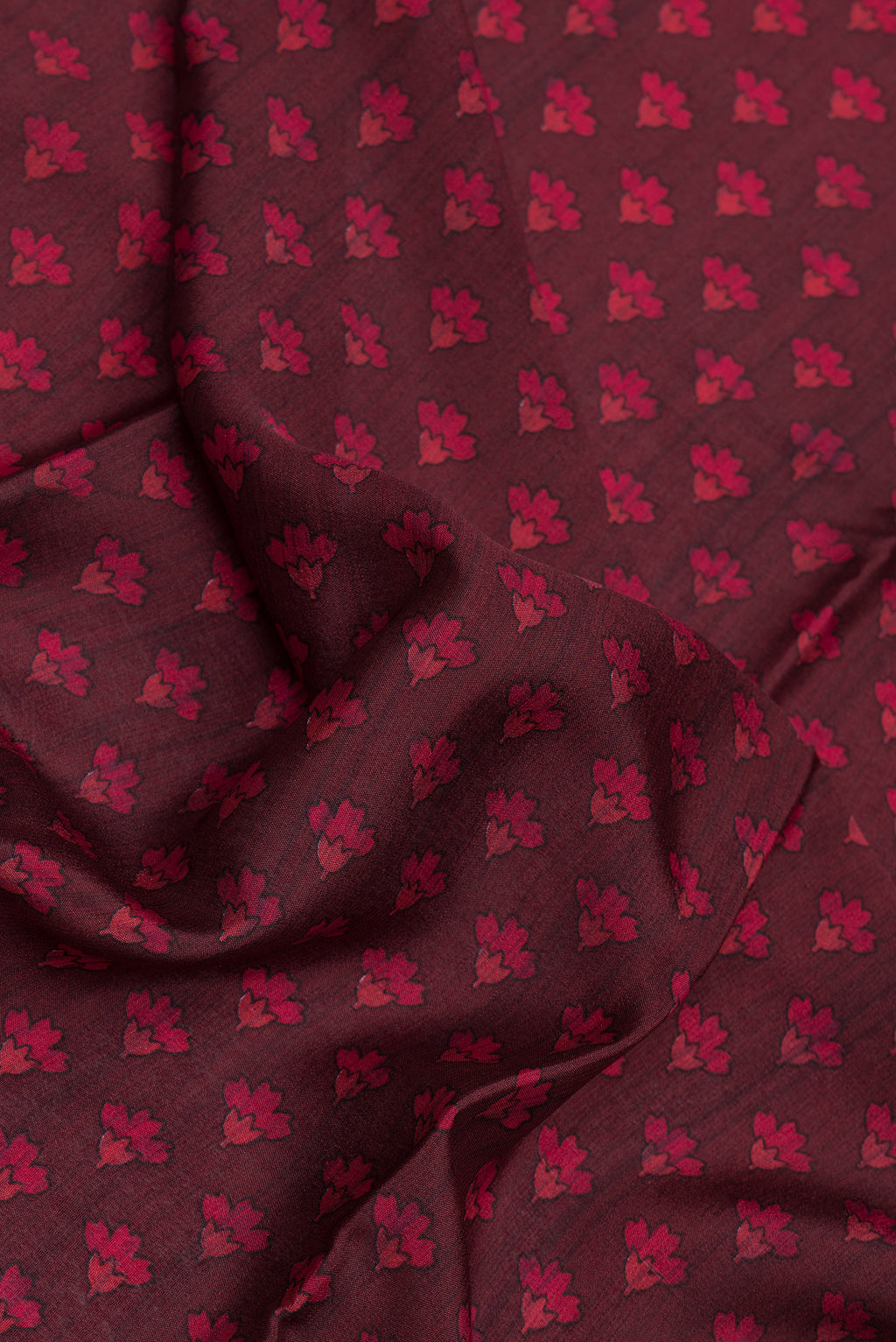 Close up of Maroon Dual Tone Crepe Saree with Printed design on the body and Zari Border.  displaying folds