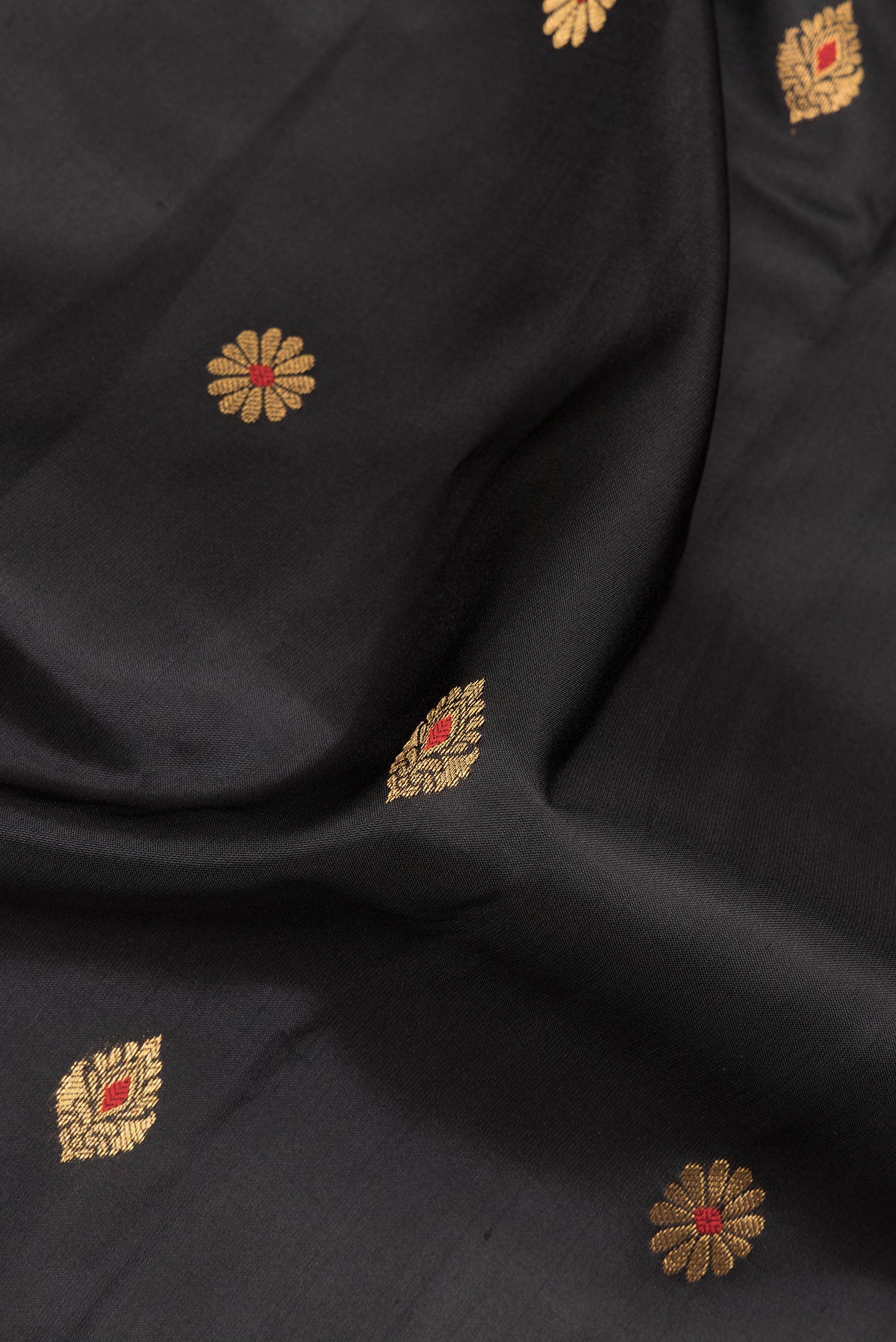 Close up of Pure Silk Black Dual Tone Soft Saree with Zari And Thread Butta on the body and Fancy Border.  displaying folds