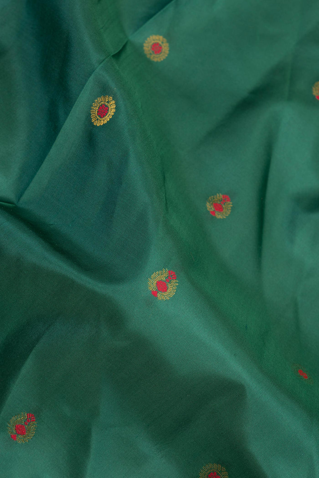 Close up of Pure Silk Bottle Green Dual Tone Soft Saree with Zari And Thread Butta on the body and Fancy Border.  displaying folds