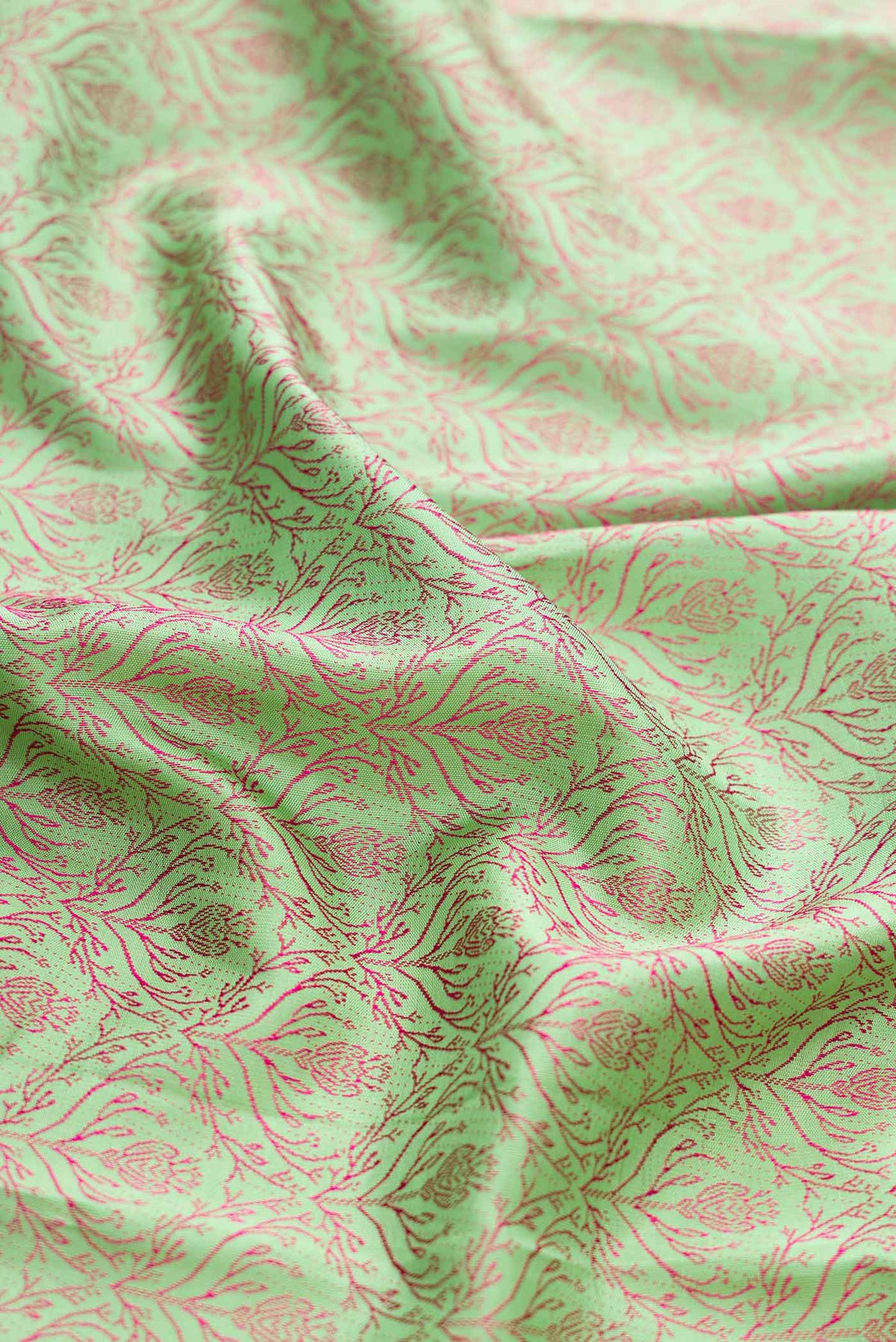 Close up of Parrot Green Dual Tone Kanchipuram Silk Saree with Jacquard design on the body and Fancy Border displaying folds