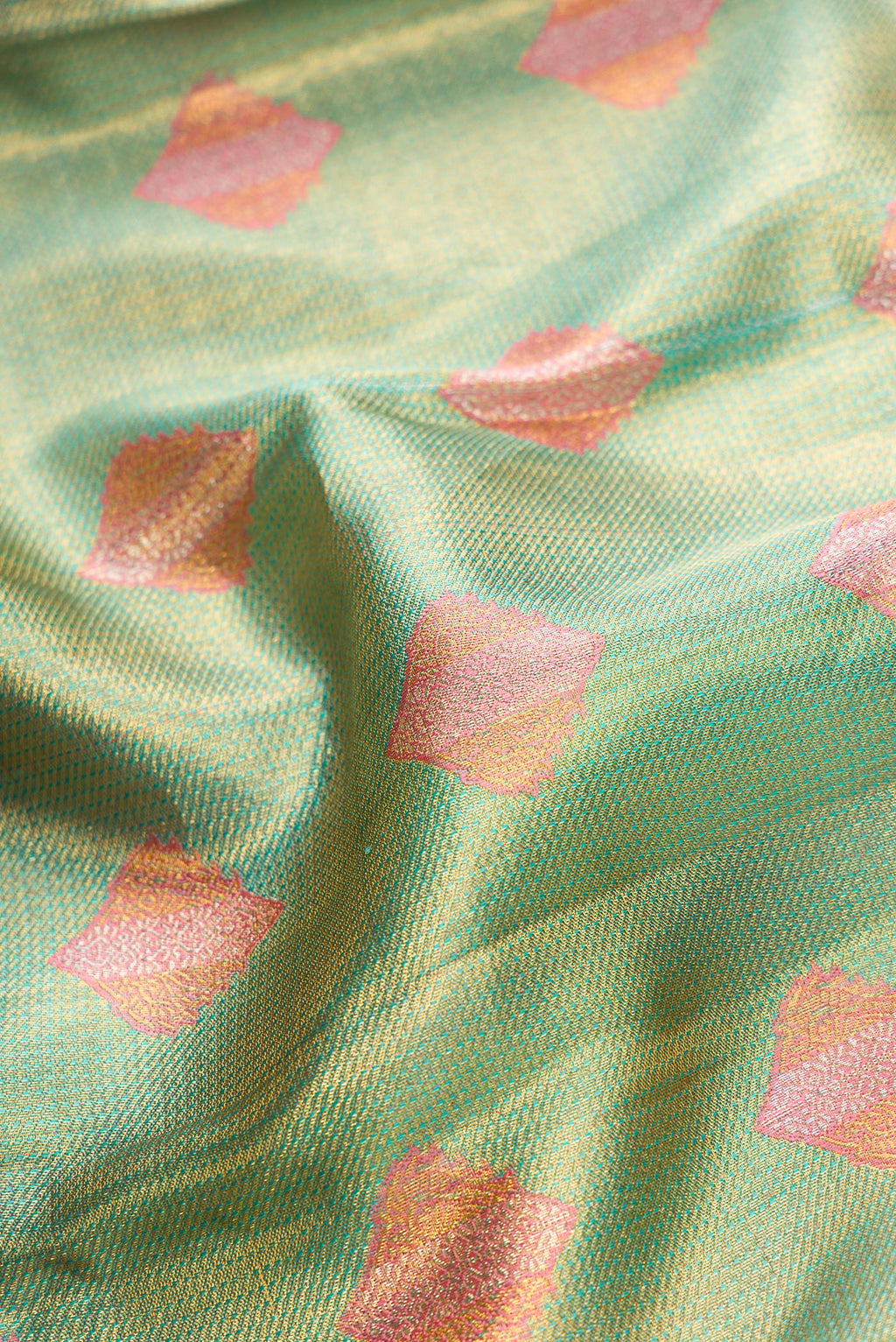 Close up of Green Dual Tone Kanjivaram Tissue Silk Saree with Zari Brocade on the body and Fancy Border.  displaying folds