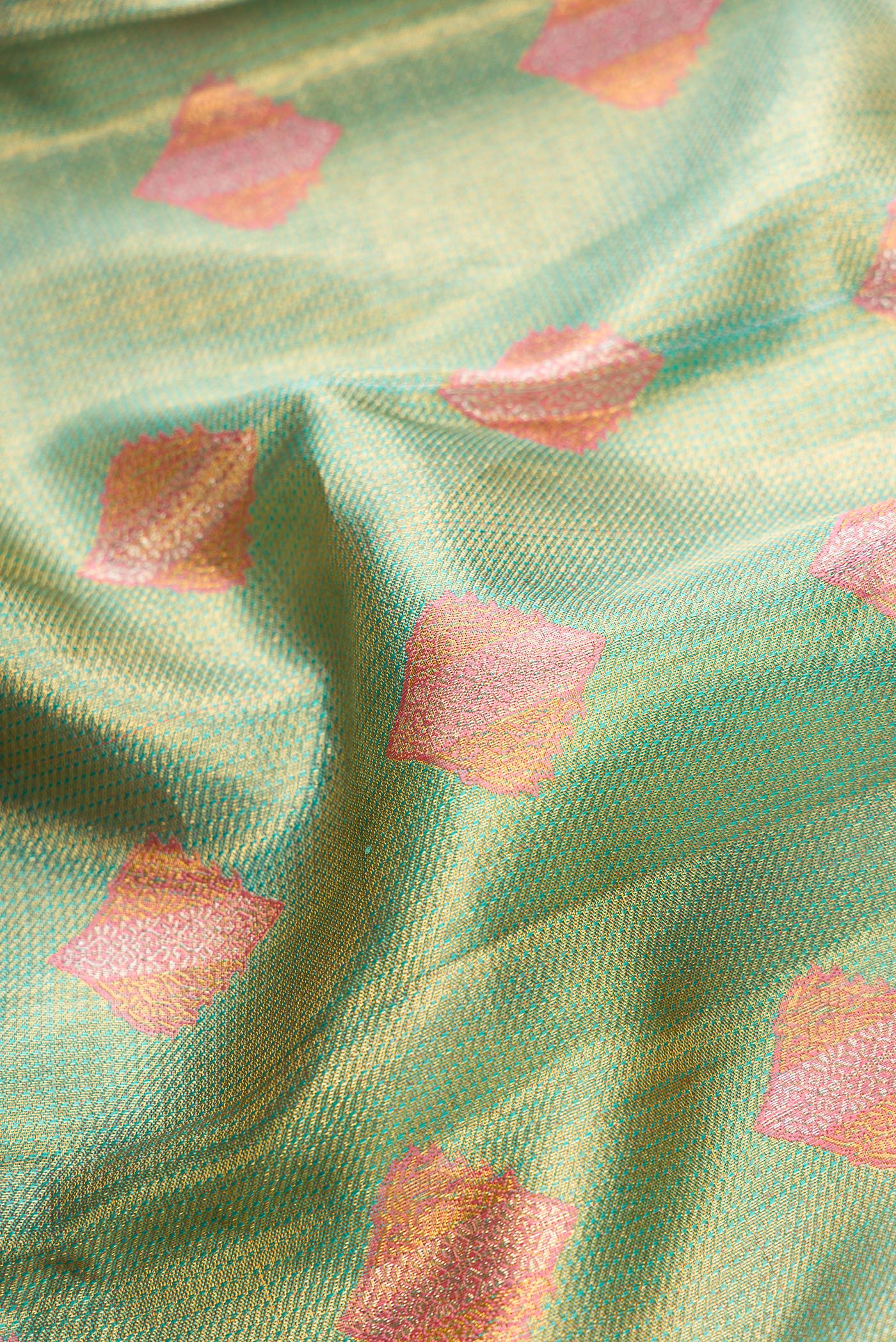 Close up of Green Dual Tone Kanjivaram Tissue Silk Saree with Zari Brocade on the body and Fancy Border.  displaying folds
