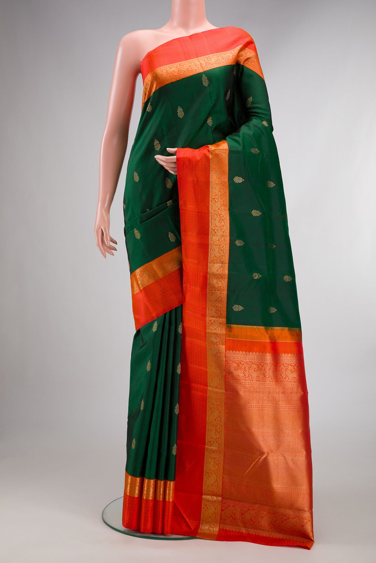 Pure Silk Pure Zari Bottle Green Dual Tone Kanchipuram Saree with Zari Butta on the body and Zari And Thread Border.  displayed on a mannequin