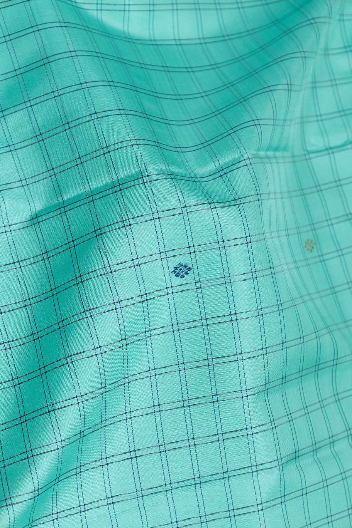 Close up of Sea Green Dual Tone Kanchipuram Silk Saree with Checked design on the body and Zari And Thread Border displaying folds