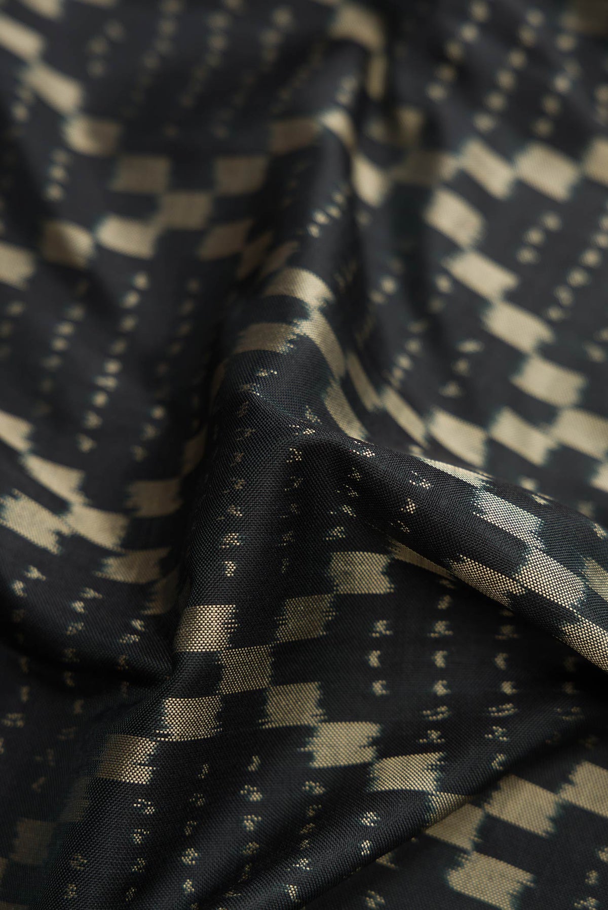 Close up of Black Pochampally Silk Saree with Pure Ikat on the body and Plain Border displaying folds