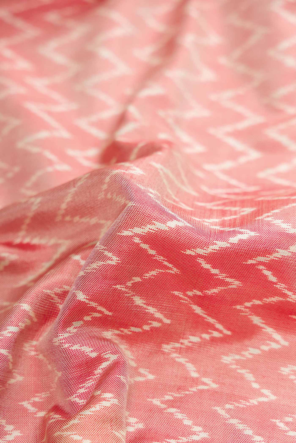 Close up of Coral Pochampally Silk Saree with Pure Ikat on the body and Zari Border displaying folds