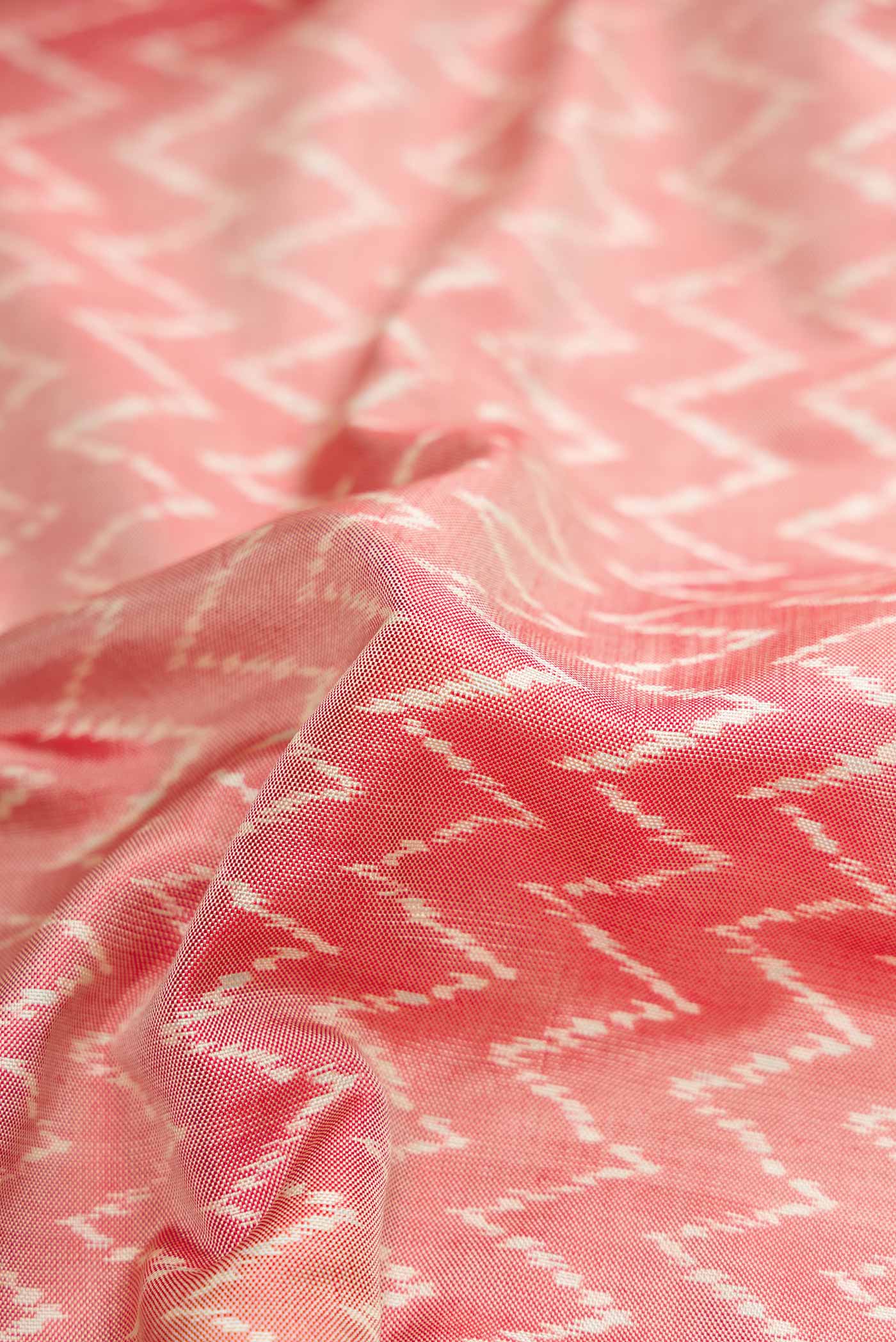 Close up of Coral Pochampally Silk Saree with Pure Ikat on the body and Zari Border displaying folds
