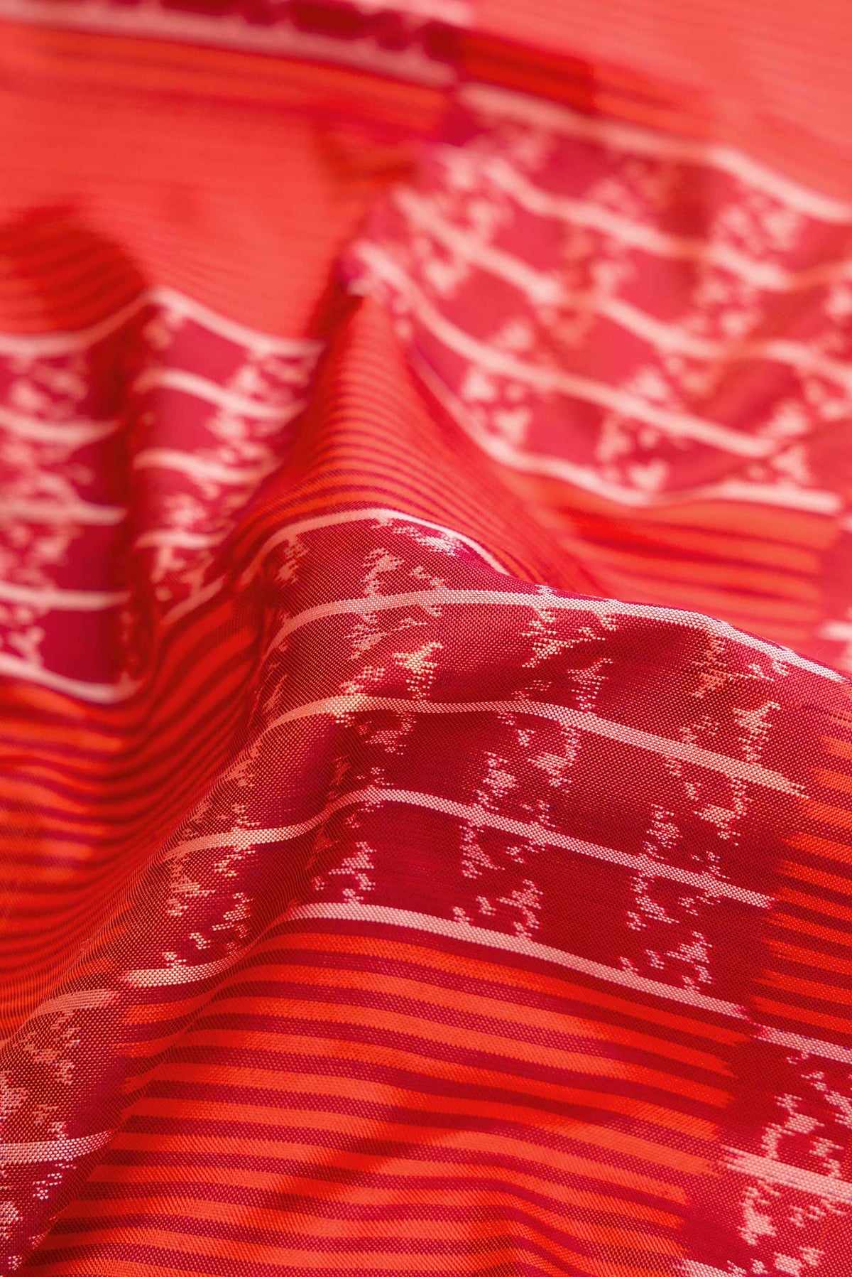 Close up of Orange Pochampally Silk Saree with Pure Ikat on the body and Zari Border displaying folds