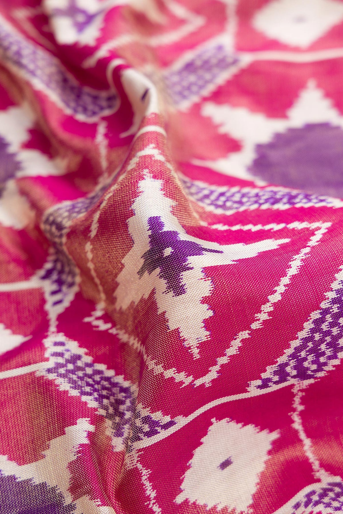 Close up of Pink Dual Tone Double Ikat Saree with Ikat Print on the body and Zari Border.  displaying folds