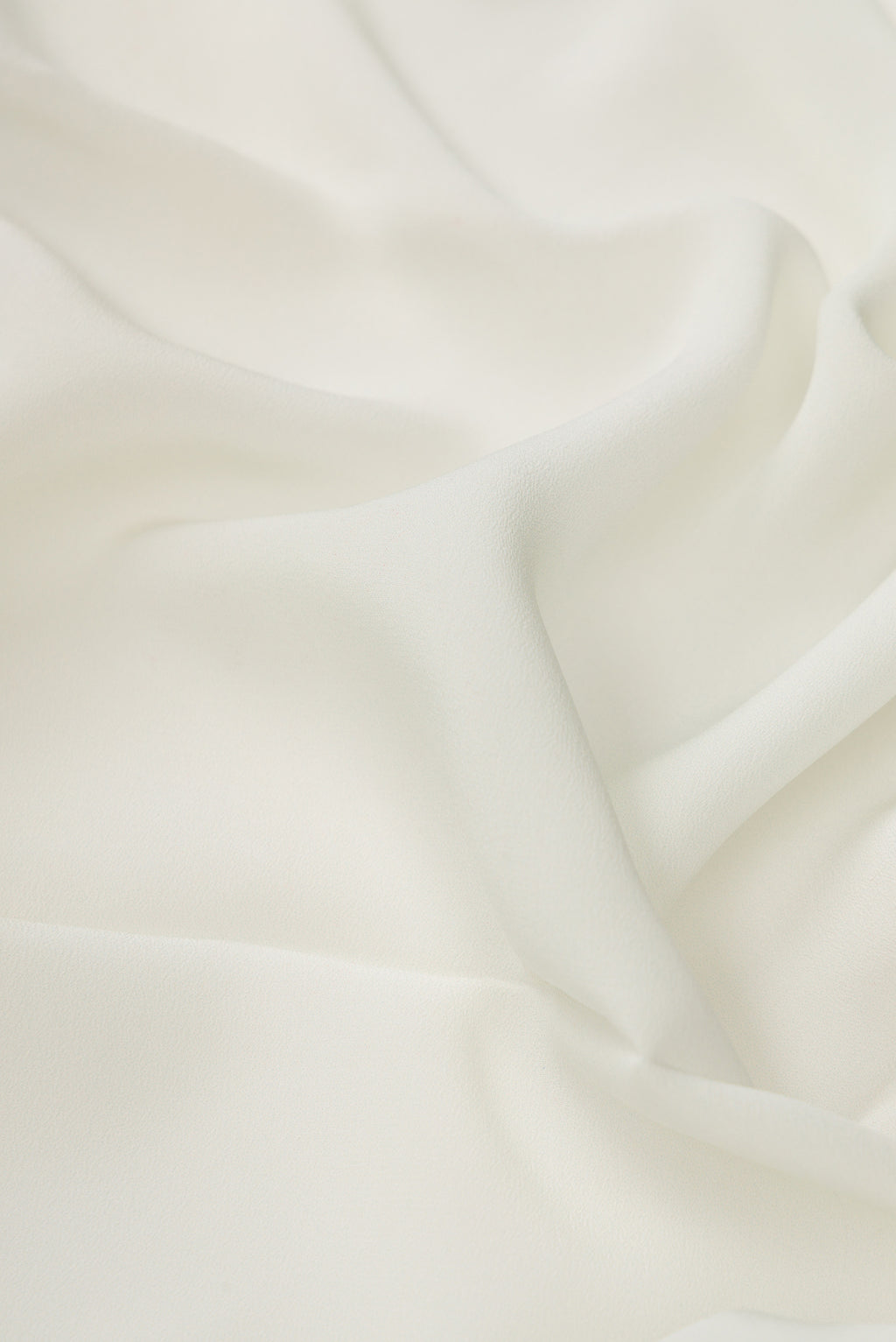 Close up of Off White Dual Tone Mysore Crepe Saree with Plain Body and Printed Border.  displaying folds