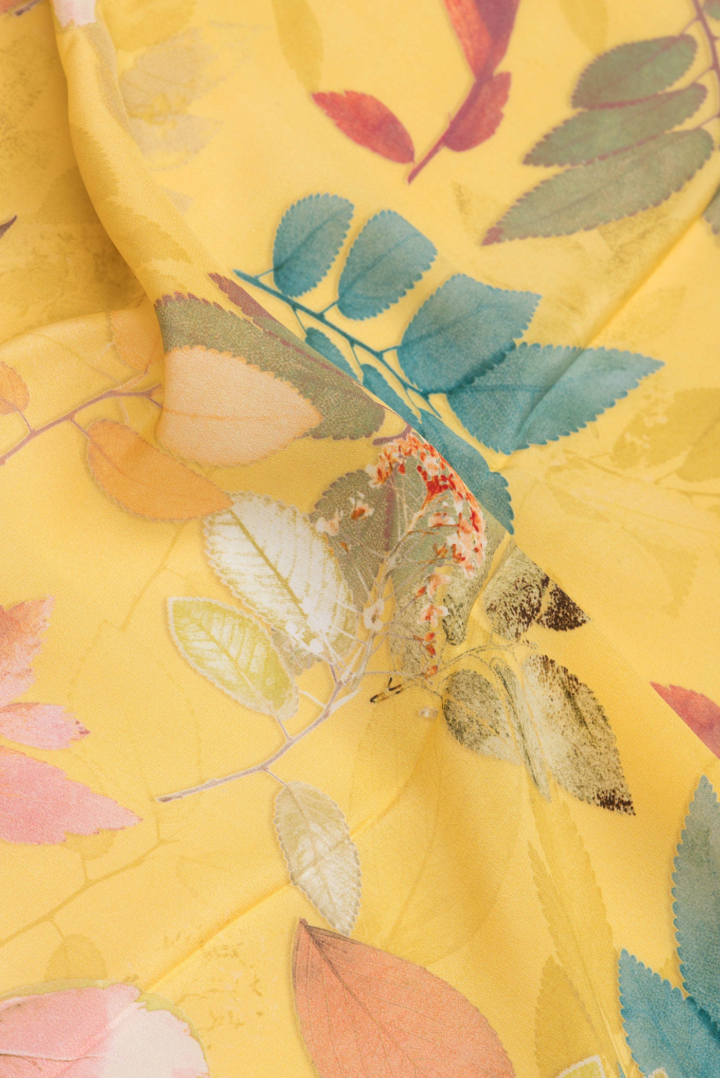 Close up of Yellow Crepe Saree with Printed design on the body and Plain Border.  displaying folds