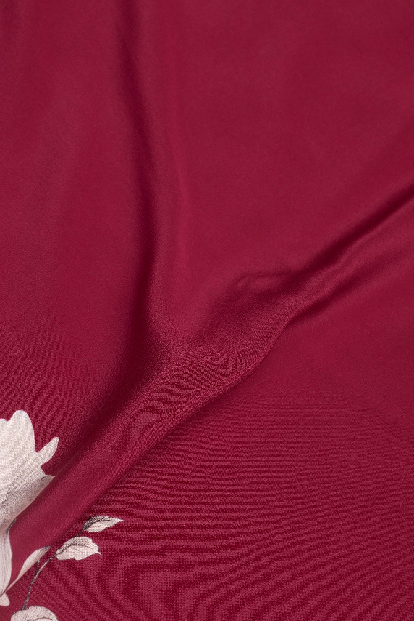 Close up of Dark Pink Dual Tone Crepe Saree with Printed design on the body and Without Border.  displaying folds