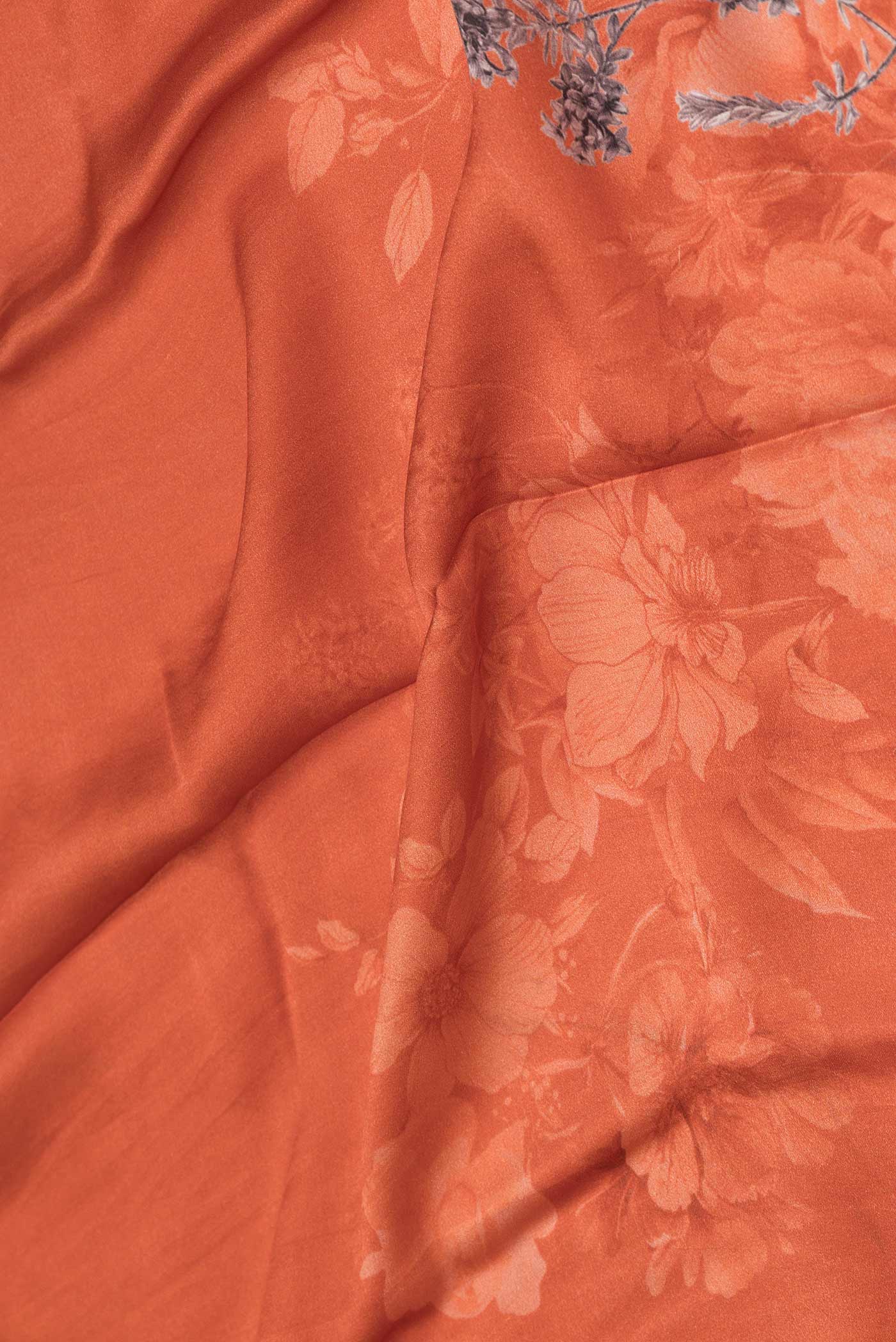 Close up of Brick Orange Dual Tone Tussar Silk Saree with Printed design on the body and Zari Border displaying folds