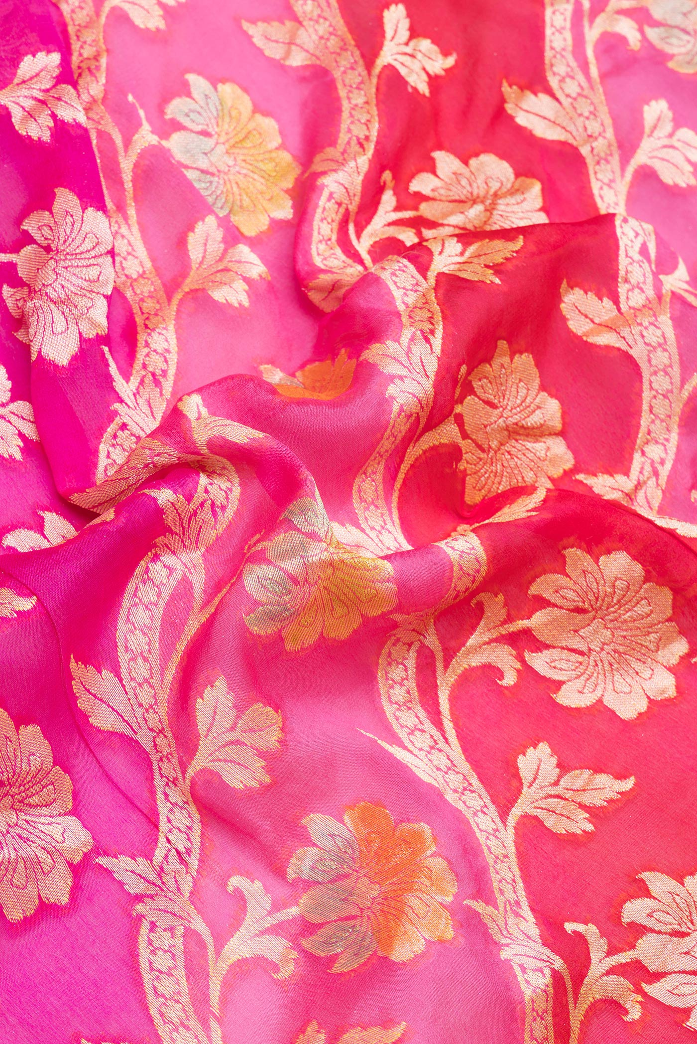 Close up of Pink Banarasi Georgette Saree with Zari And Thread Butta on the body and Zari Border.  displaying folds
