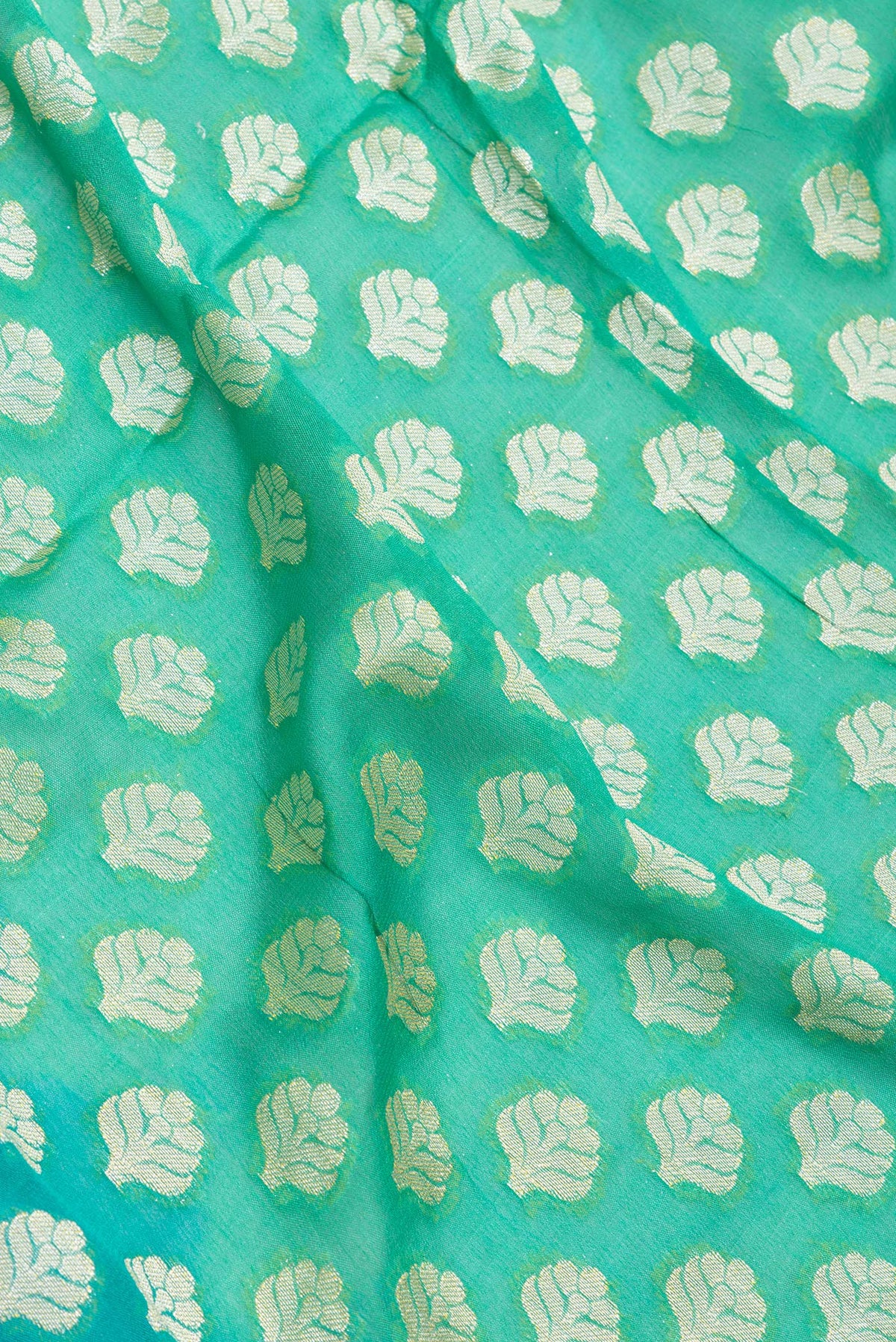 Close up of Sea Green Banarasi Georgette Saree with Zari Brocade on the body and Zari And Thread Border.  displaying folds