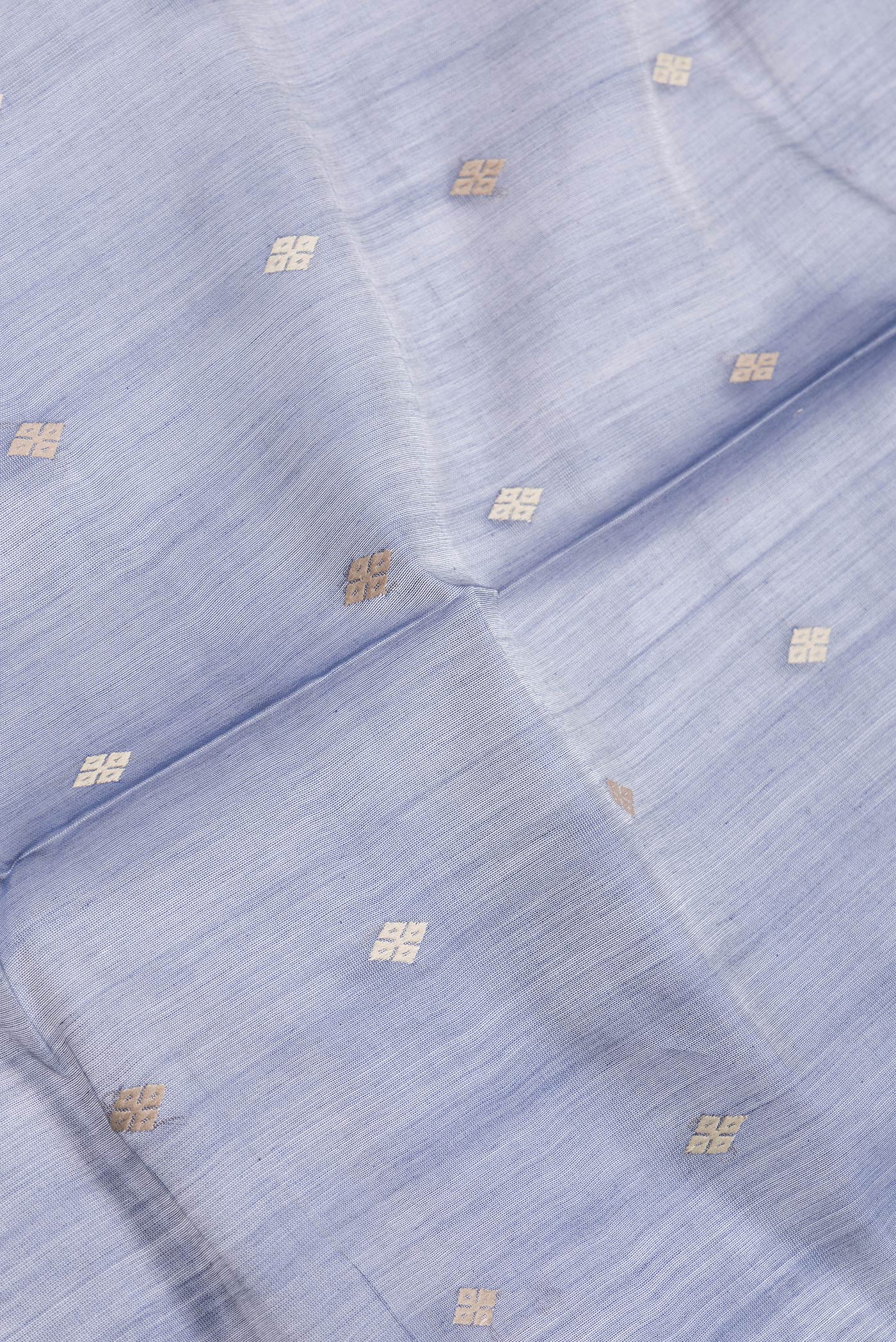 Close up of Grey Dual Tone Tussar Silk Saree with Thread Butta on the body and Zari And Thread Border.  displaying folds