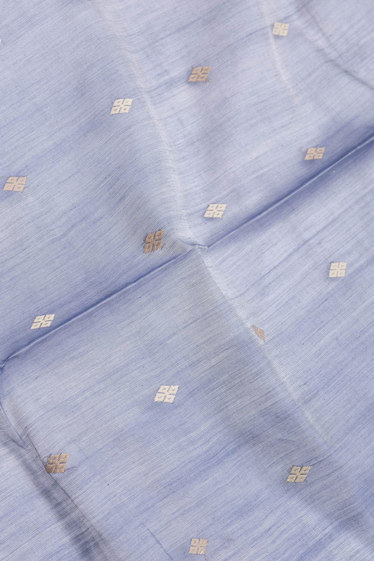 Close up of Grey Dual Tone Tussar Silk Saree with Thread Butta on the body and Zari And Thread Border.  displaying folds