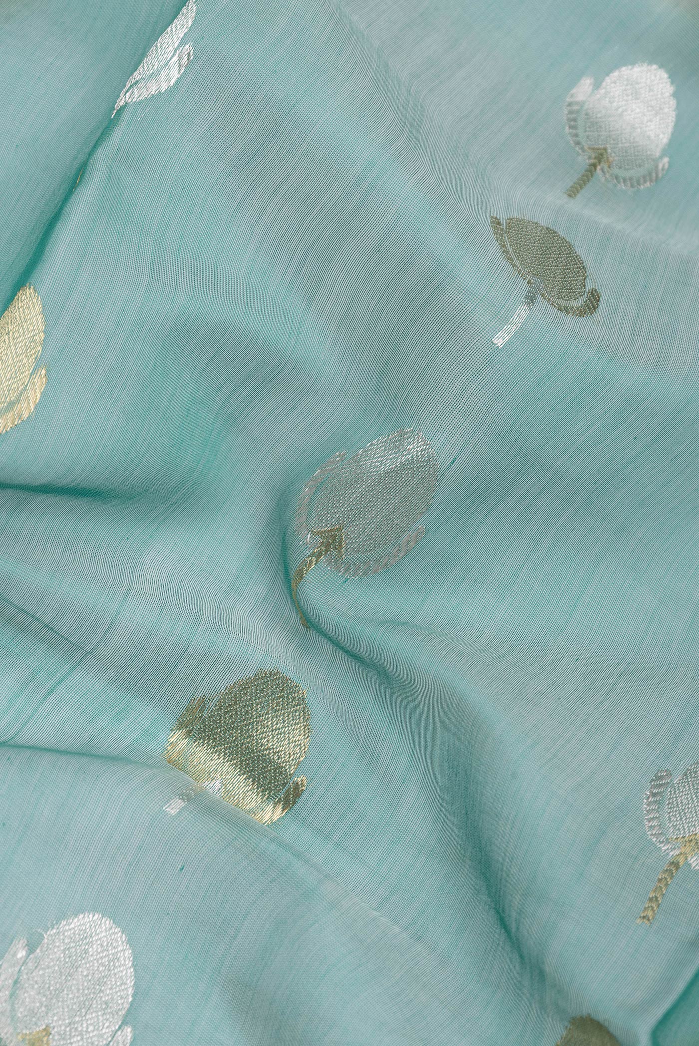 Close up of Sea Green Dual Tone Organza Silk Saree with Zari Butta on the body and Zari Border.  displaying folds