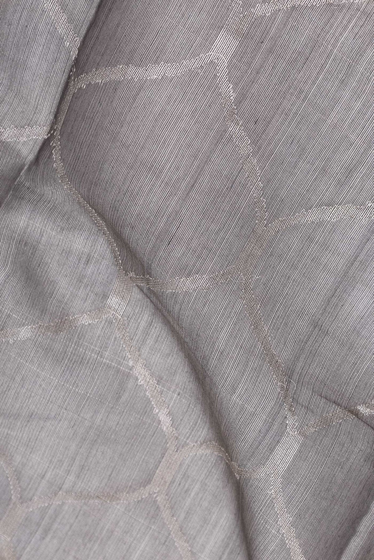 Close up of Grey Dual Tone Organza Silk Saree with Zari Brocade on the body and Zari Border.  displaying folds
