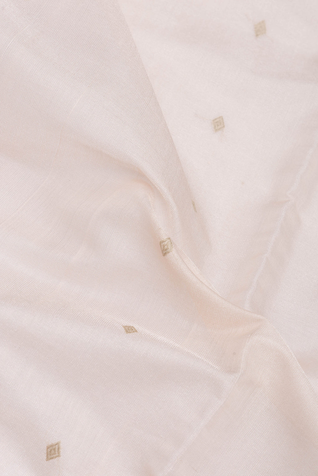 Close up of Rose Gold Dual Tone Tussar Silk Saree with Zari Butta on the body and Plain Border.  displaying folds