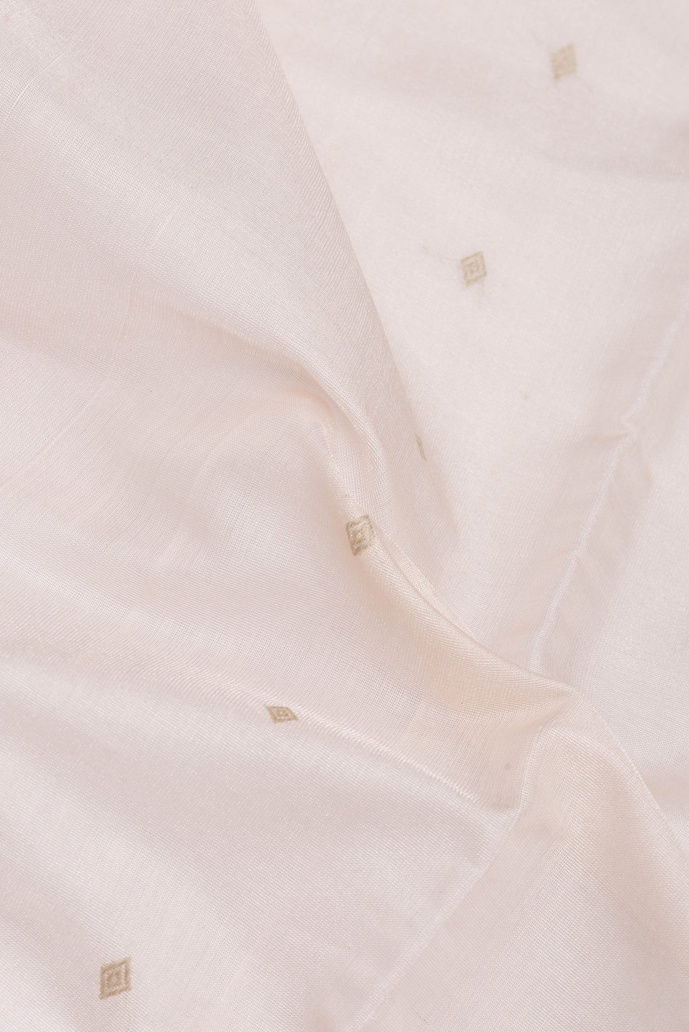 Close up of Rose Gold Dual Tone Tussar Silk Saree with Zari Butta on the body and Plain Border.  displaying folds