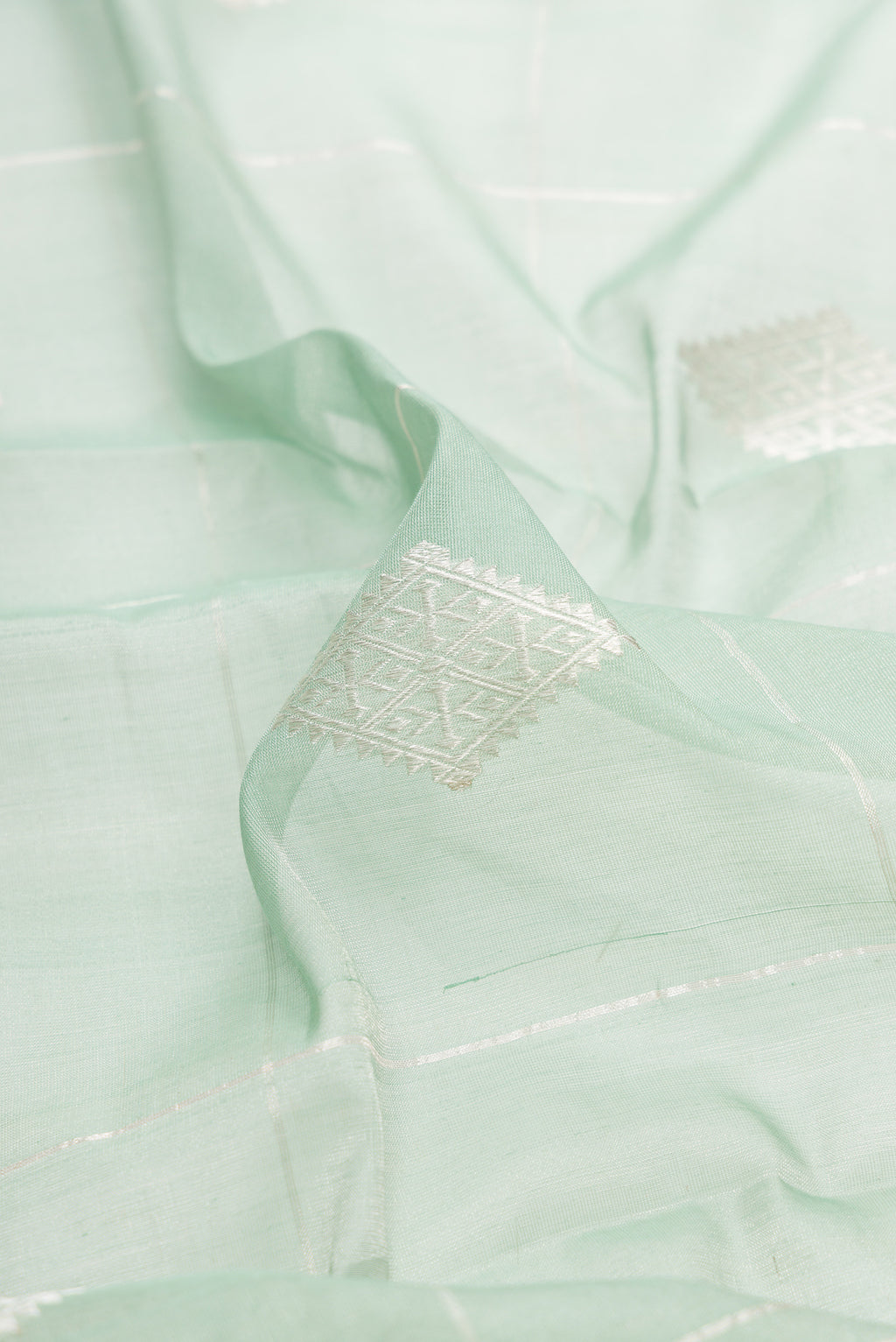 Close up of Light Green Dual Tone Chanderi Tissue Silk Saree with Zari Butta on the body and Zari Border.  displaying folds