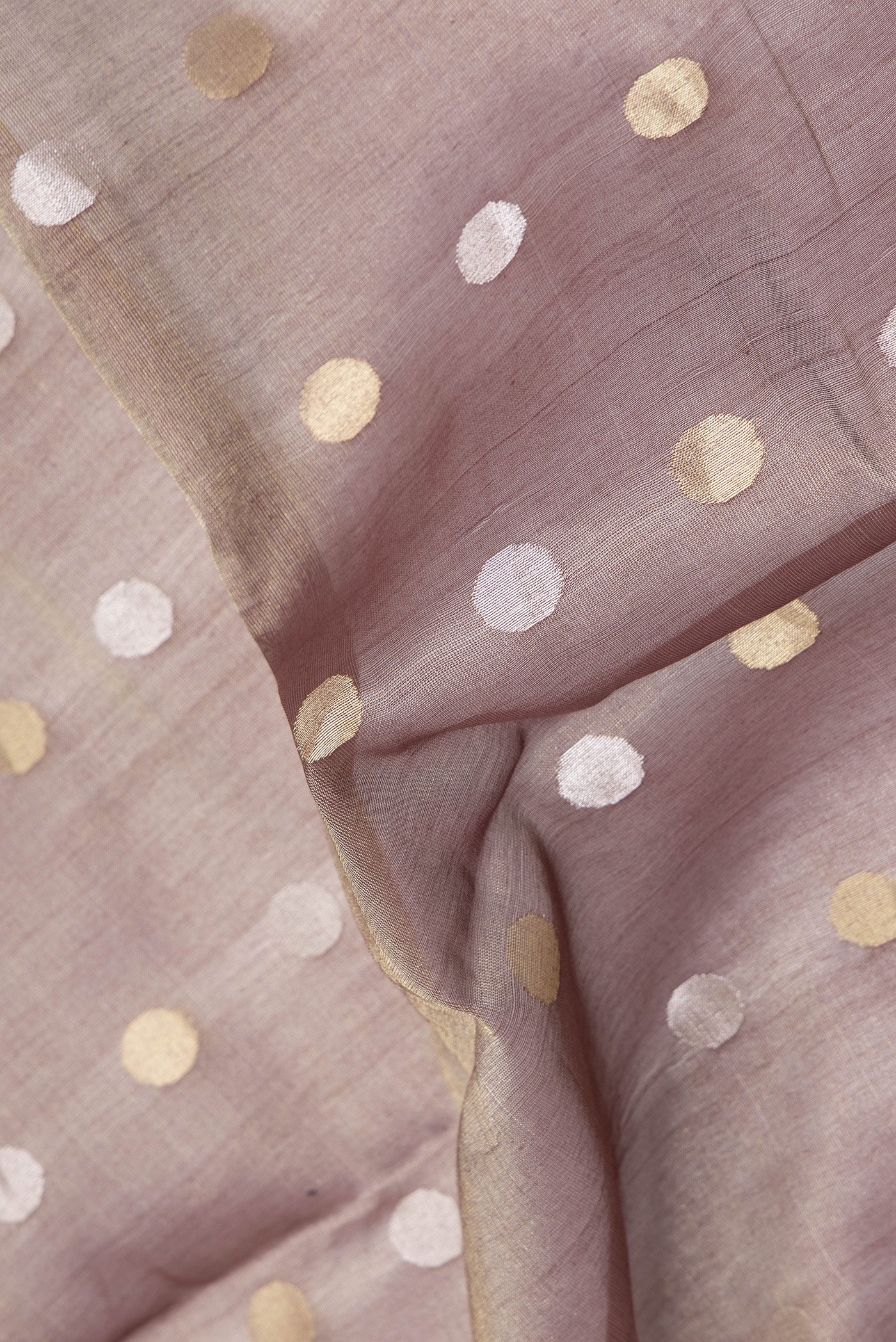Close up of Brown Dual Tone Tussar Silk Saree with Zari Butta on the body and Thin Zari Line.  displaying folds