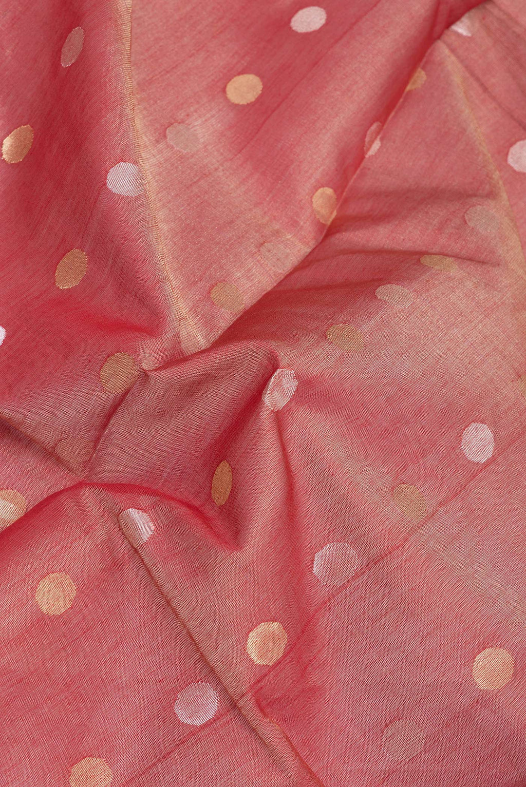Close up of Coral Tussar Silk Saree with Zari Butta on the body and Zari Border.  displaying folds