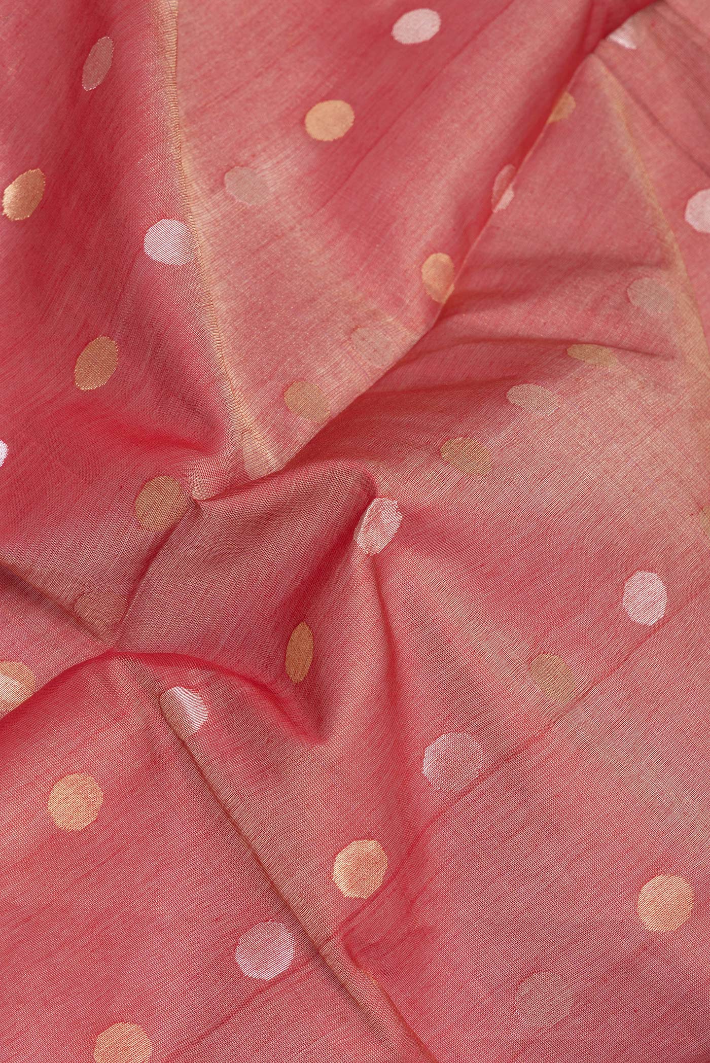 Close up of Coral Tussar Silk Saree with Zari Butta on the body and Zari Border.  displaying folds