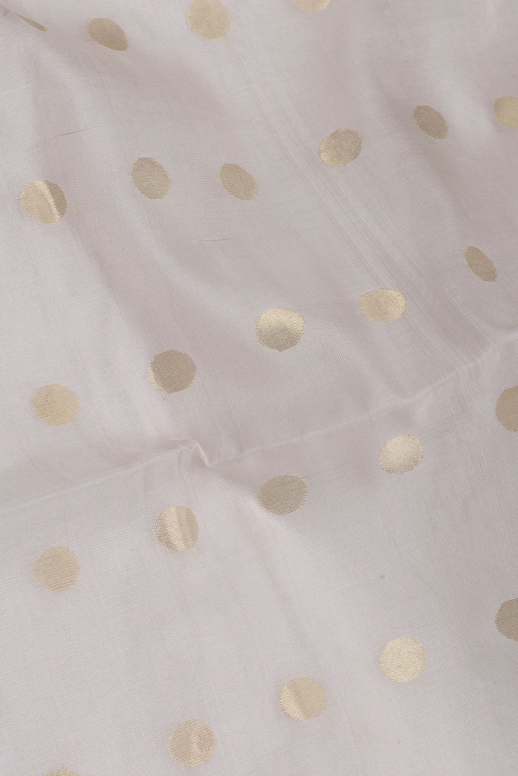 Close up of Beige Dual Tone Chanderi Silk Saree with Zari Butta on the body and Thin Zari Line.  displaying folds