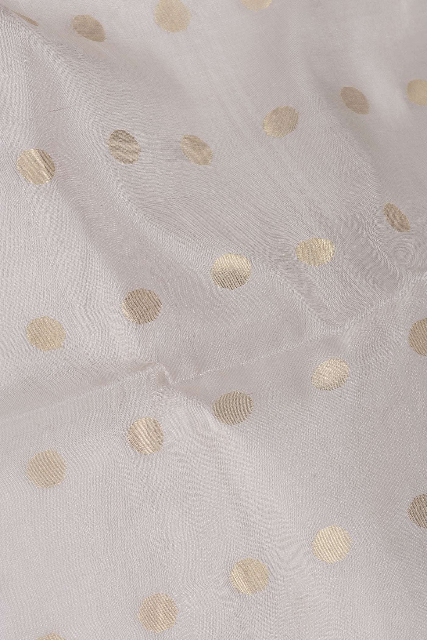 Close up of Beige Dual Tone Chanderi Silk Saree with Zari Butta on the body and Thin Zari Line.  displaying folds