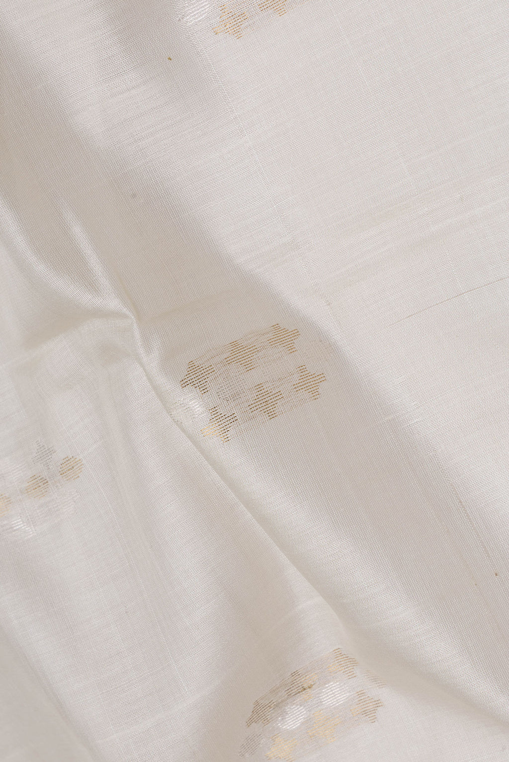Close up of Beige Dual Tone Tussar Silk Saree with Zari Butta on the body and Fancy Border.  displaying folds