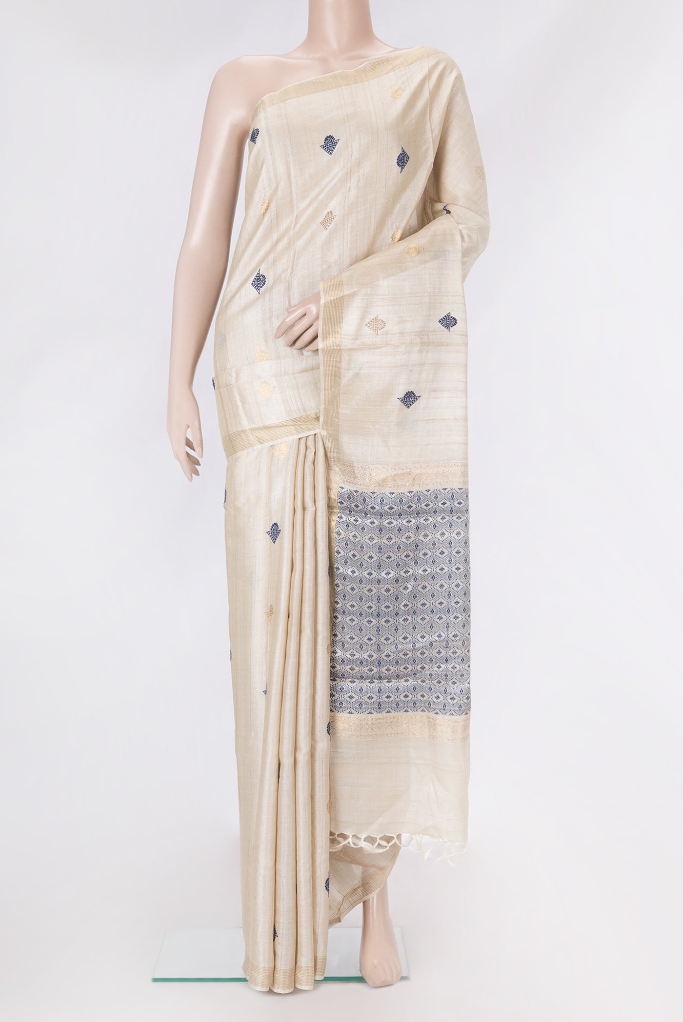 Beige Dual Tone Tussar Silk Saree with Zari And Thread Butta on the body and Zari Border.  displayed on a mannequin