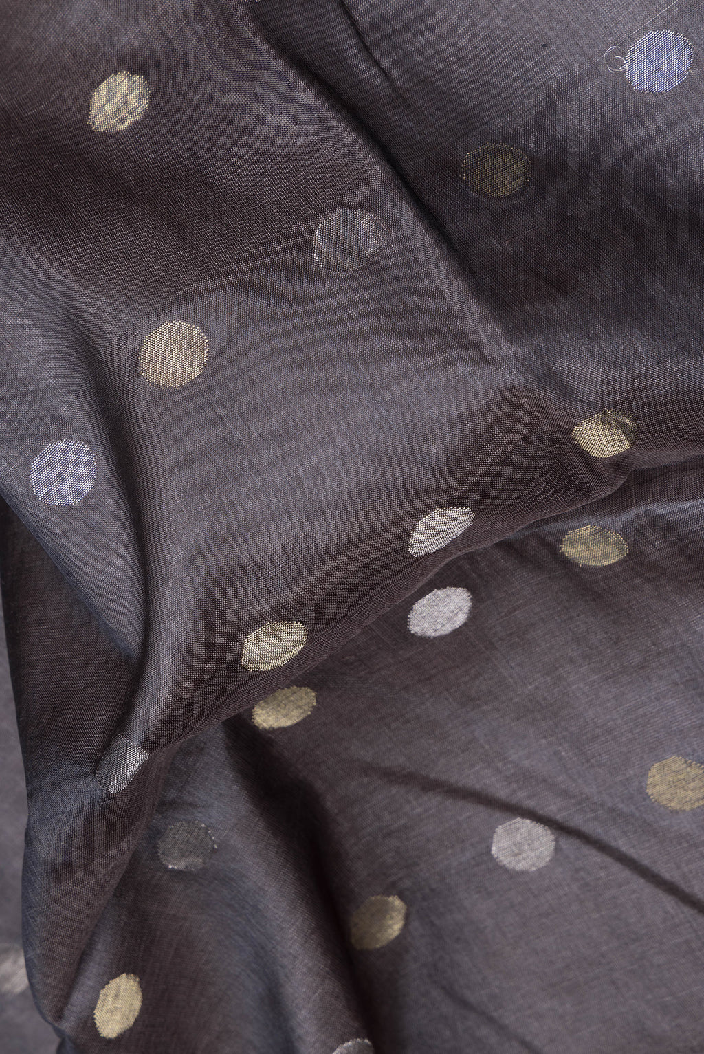 Close up of Grey Dual Tone Tussar Silk Saree with Zari Butta on the body and Zari Border.  displaying folds