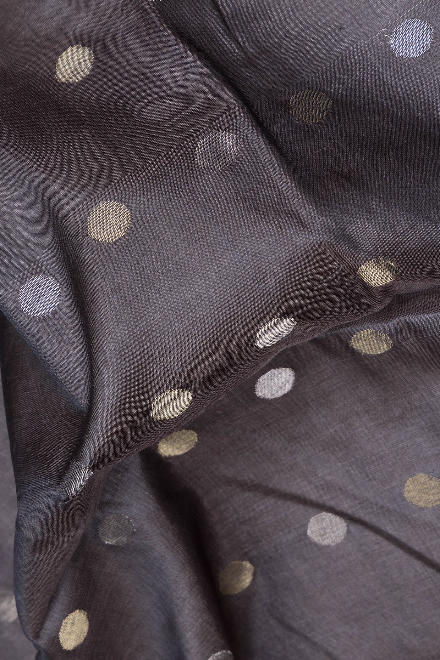 Close up of Grey Dual Tone Tussar Silk Saree with Zari Butta on the body and Zari Border.  displaying folds