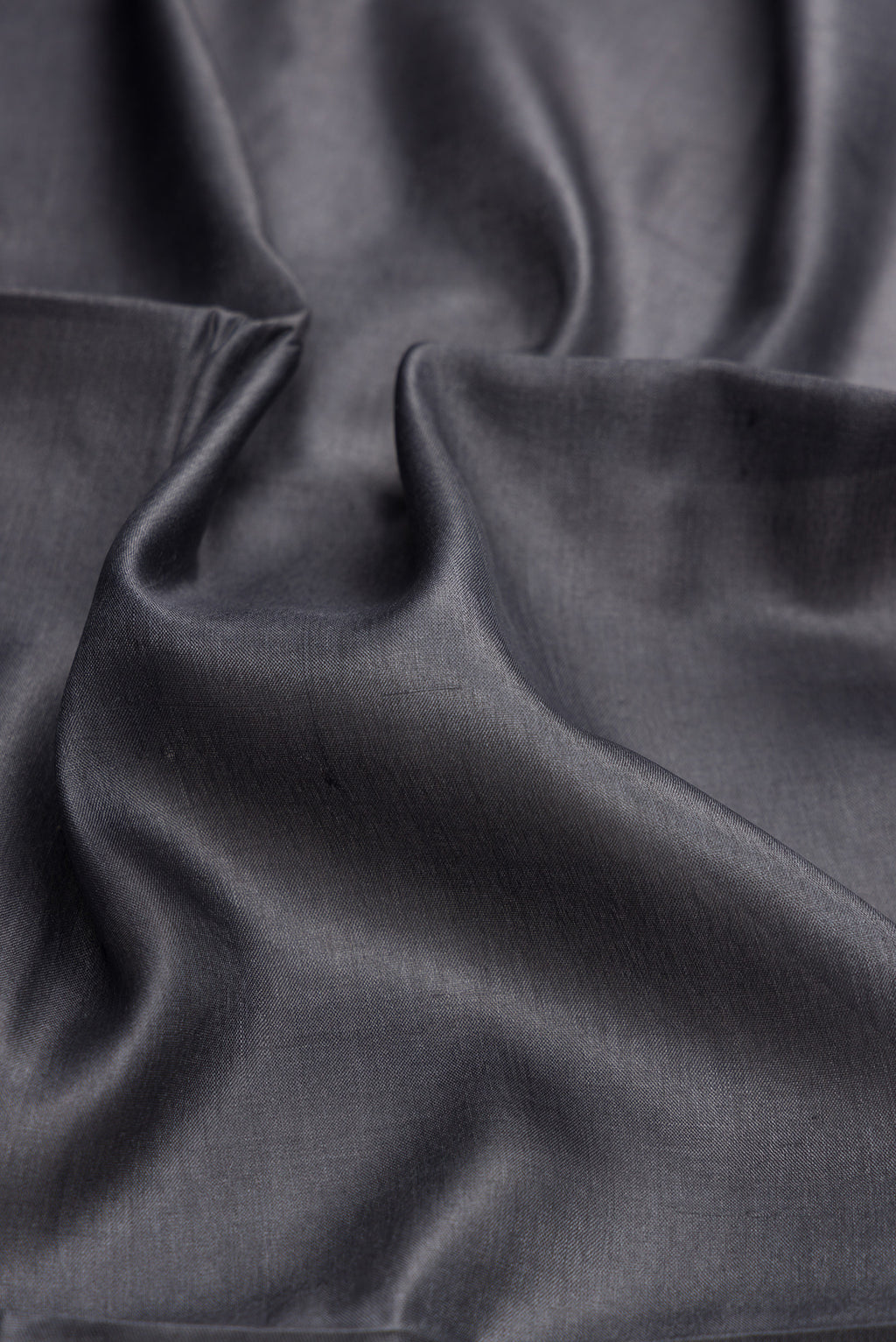 Close up of Grey Dual Tone Tussar Silk Saree with Plain Body and Fancy Border.  displaying folds