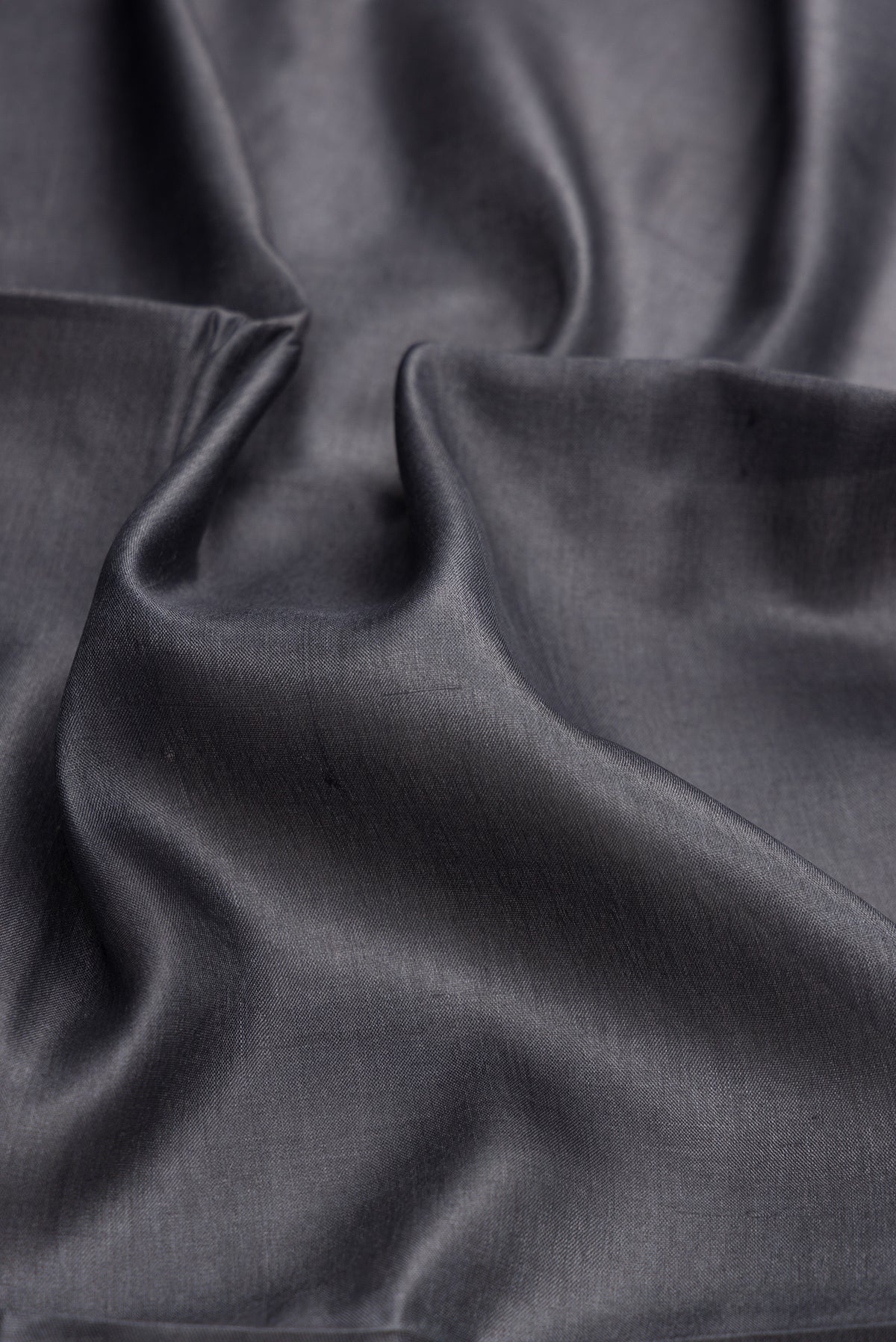 Close up of Grey Dual Tone Tussar Silk Saree with Plain Body and Fancy Border.  displaying folds