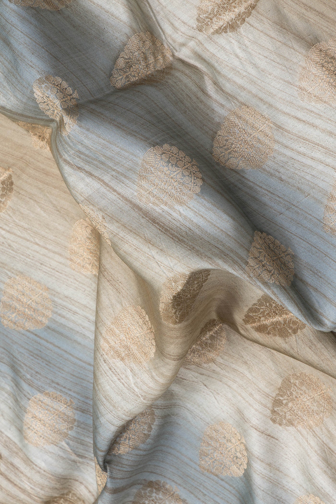 Close up of Grey Dual Tone Banarasi Raw Silk Saree with Zari Butta on the body and Zari Border.  displaying folds