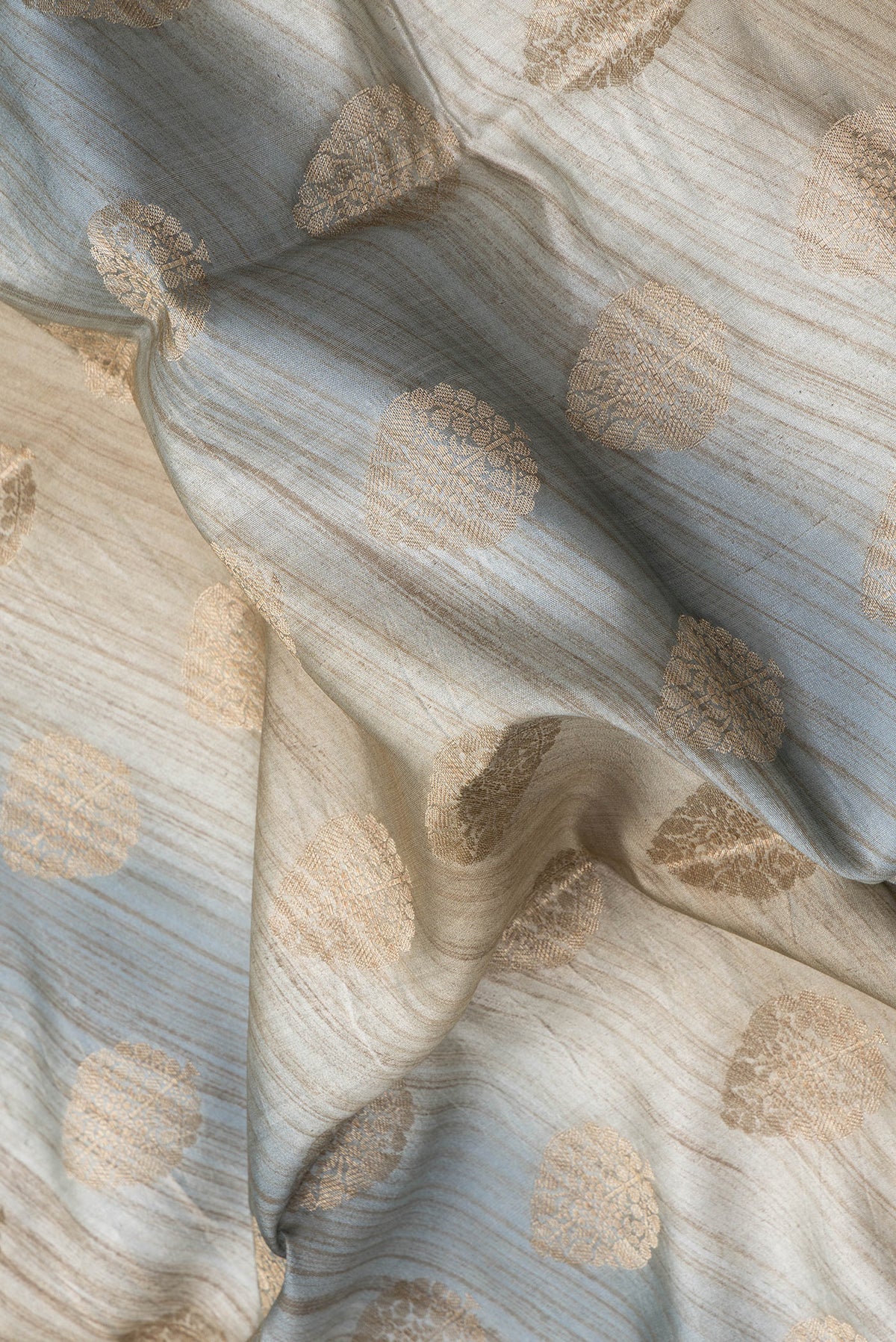 Close up of Grey Dual Tone Banarasi Raw Silk Saree with Zari Butta on the body and Zari Border.  displaying folds