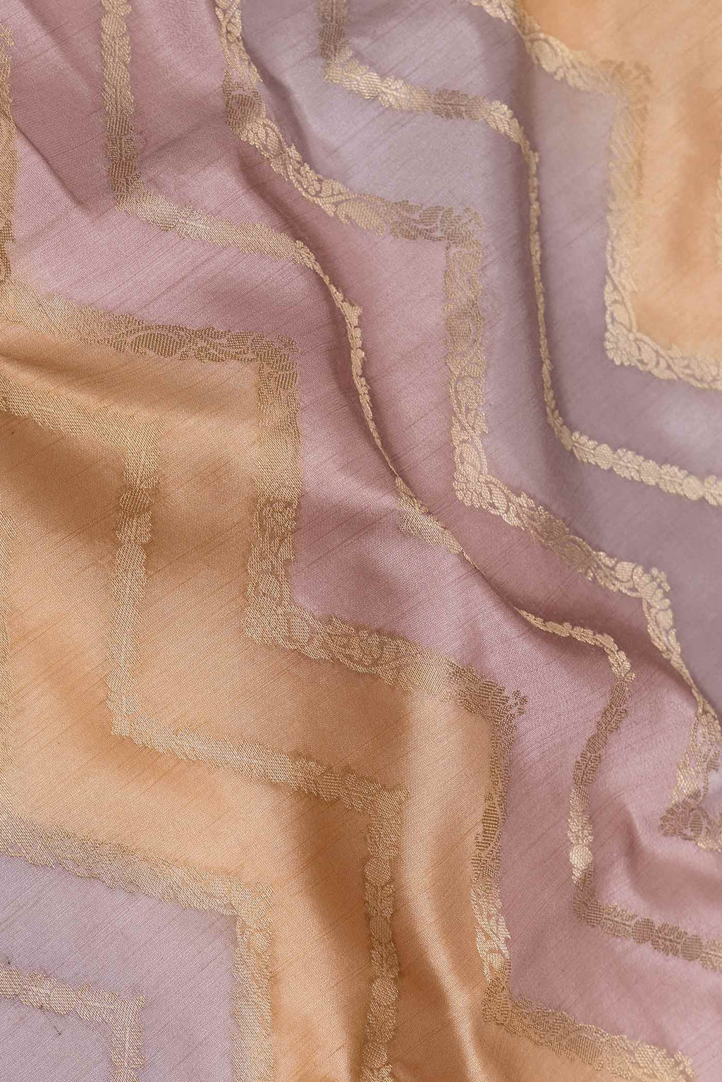 Close up of Lavender and Peach Color Banarasi Raw Silk Saree with Zig Zag design on the body and Zari Border displaying folds