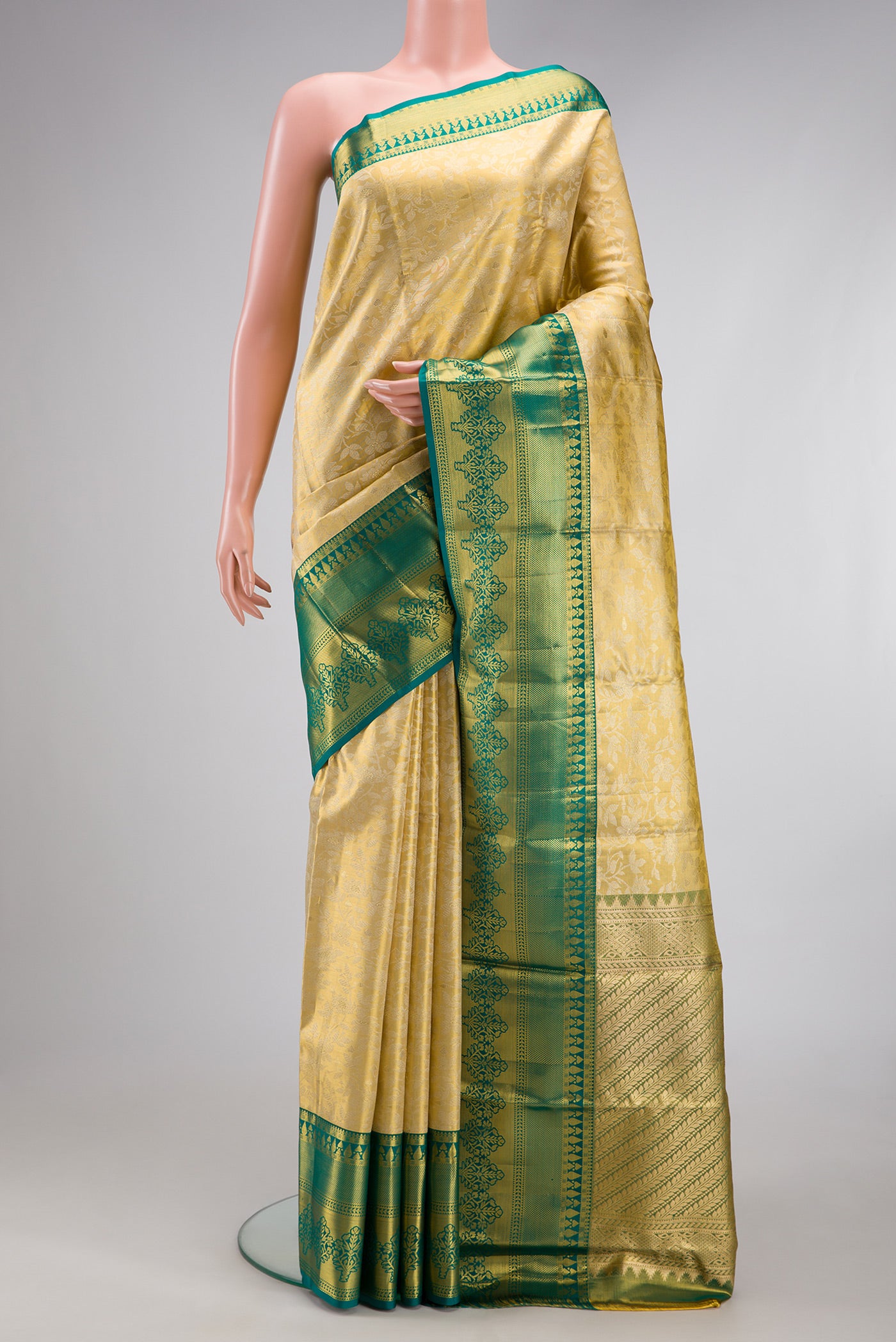 Gold Dual Tone Kanjivaram Tissue Silk Saree with Zari Brocade on the body and Fancy Border.  displayed on a mannequin