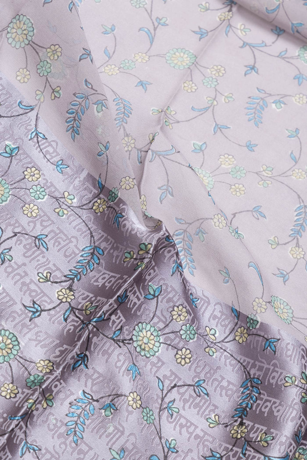 Close up of Grey Dual Tone Mysore Georgette Saree with Printed design on the body and Printed Border.  displaying folds
