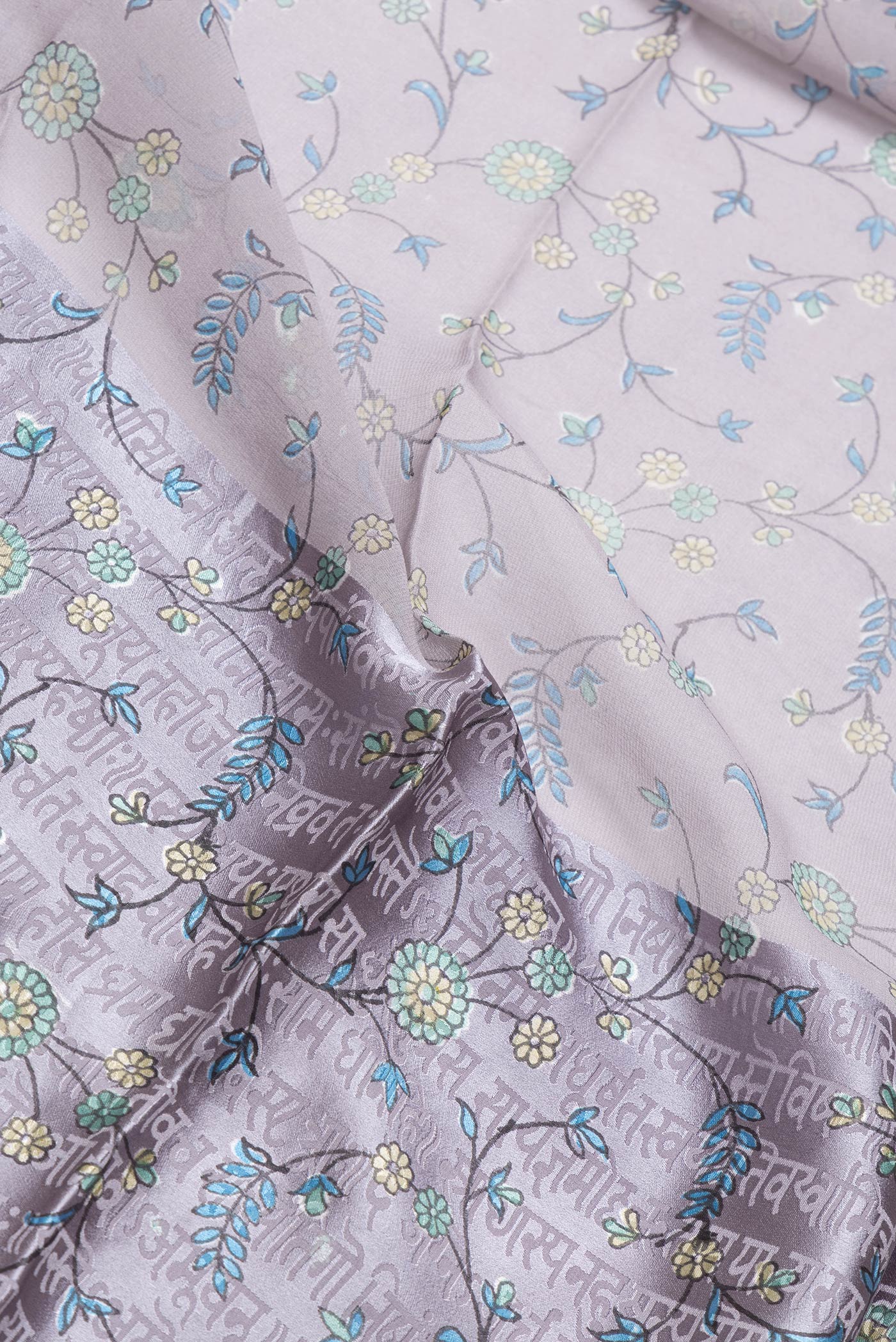 Close up of Grey Dual Tone Mysore Georgette Saree with Printed design on the body and Printed Border.  displaying folds