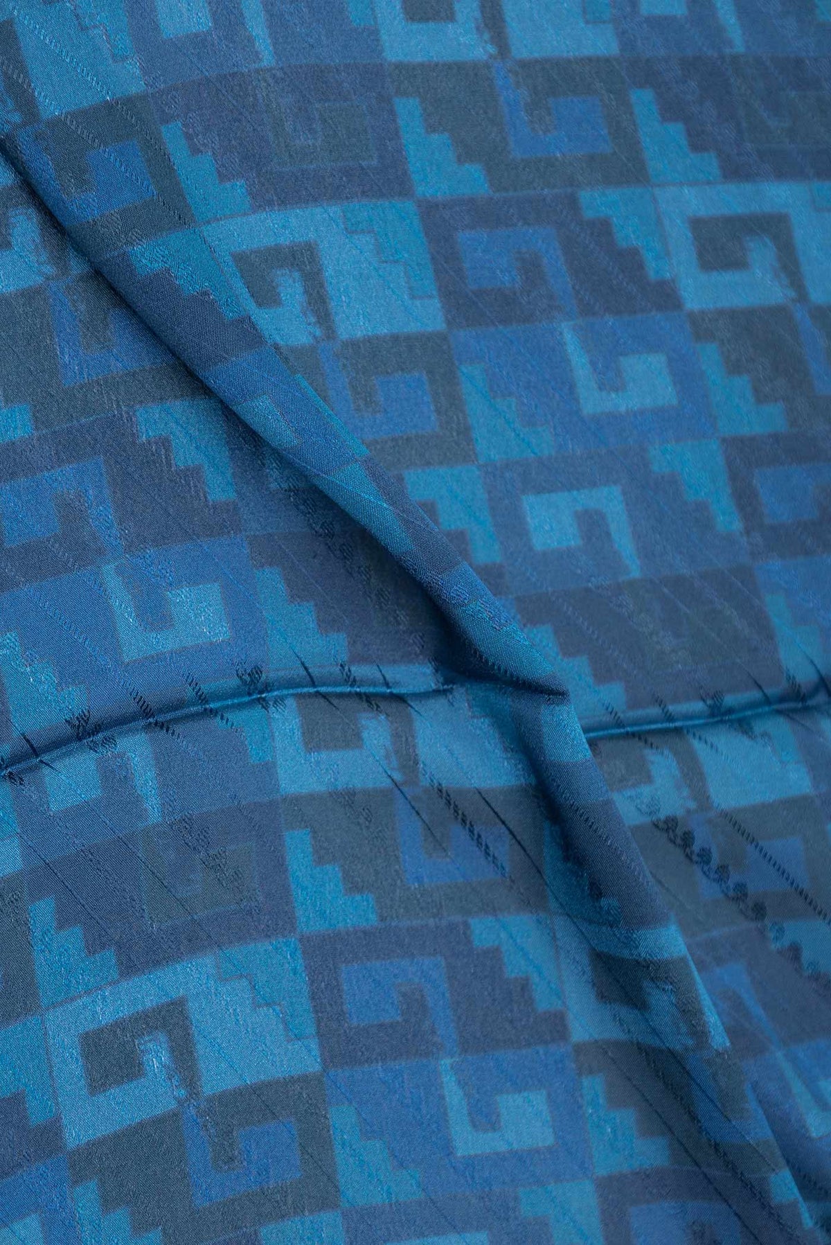 Close up of Blue Dual Tone Mysore Crepe Saree with Printed design on the body and Zari Border displaying folds