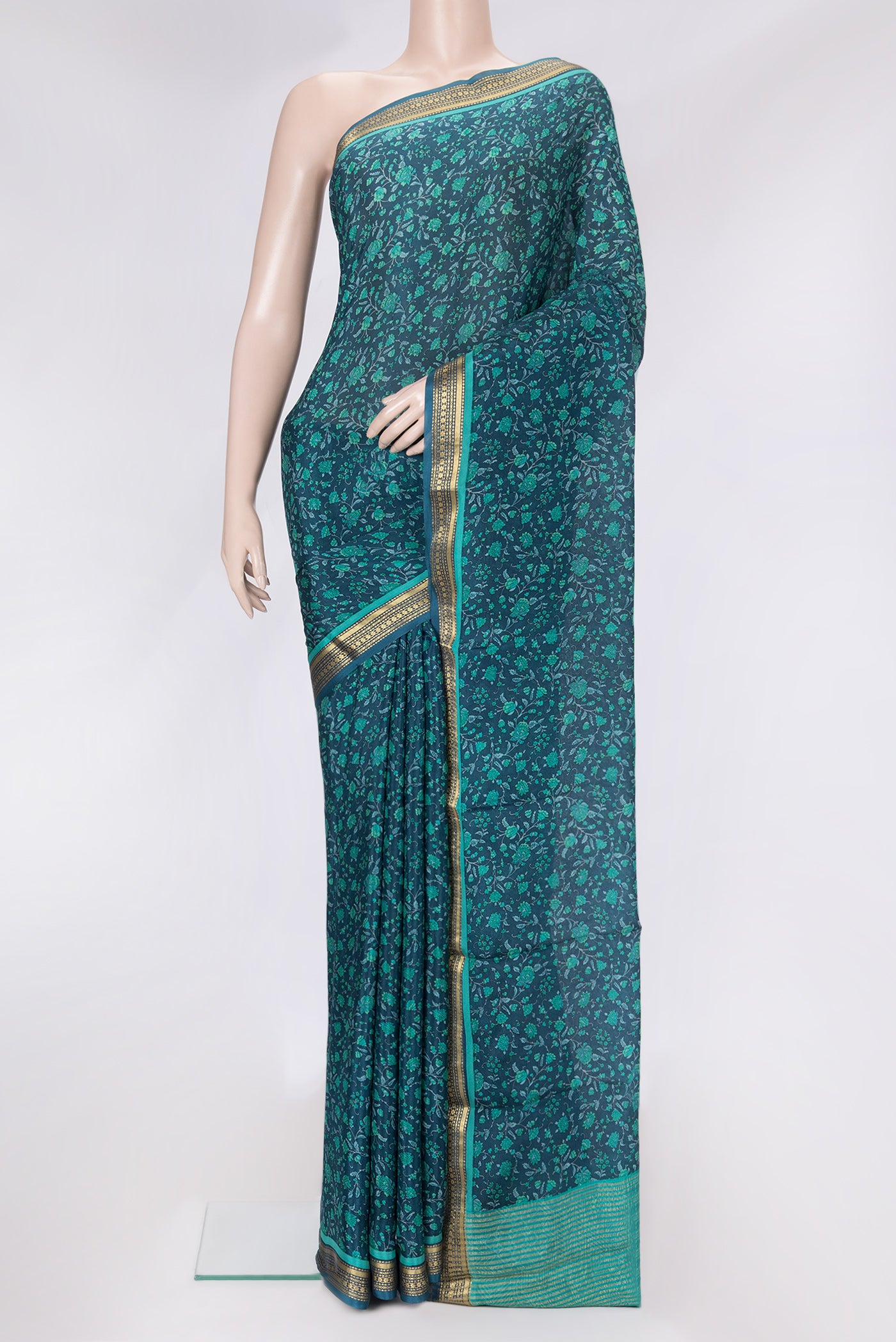 Peacock Blue Dual Tone Mysore Crepe Saree with Printed design on the body and Zari Border.  displayed on a mannequin