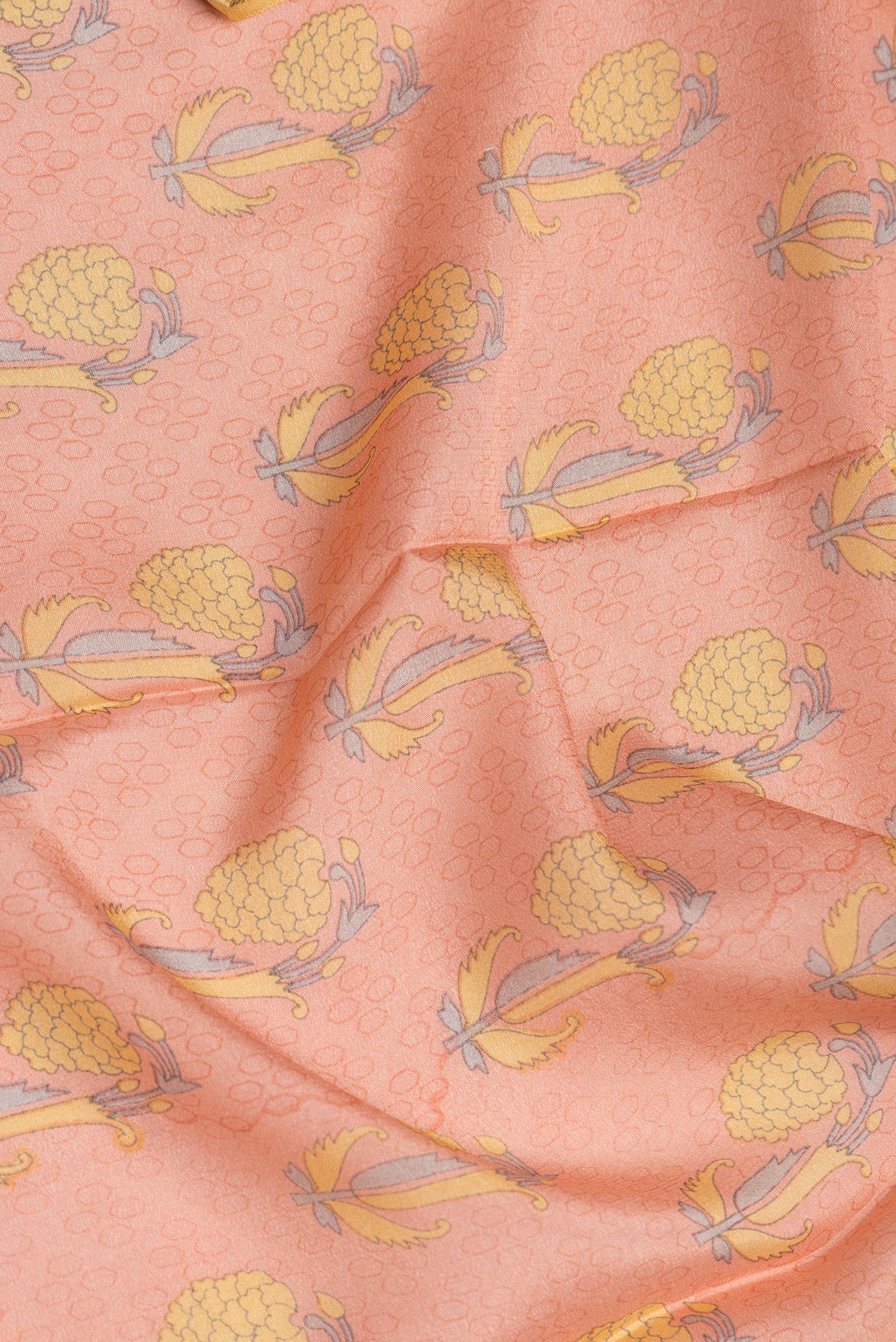 Close up of Peach Dual Tone Crepe Saree with Printed design on the body and Zari Border.  displaying folds