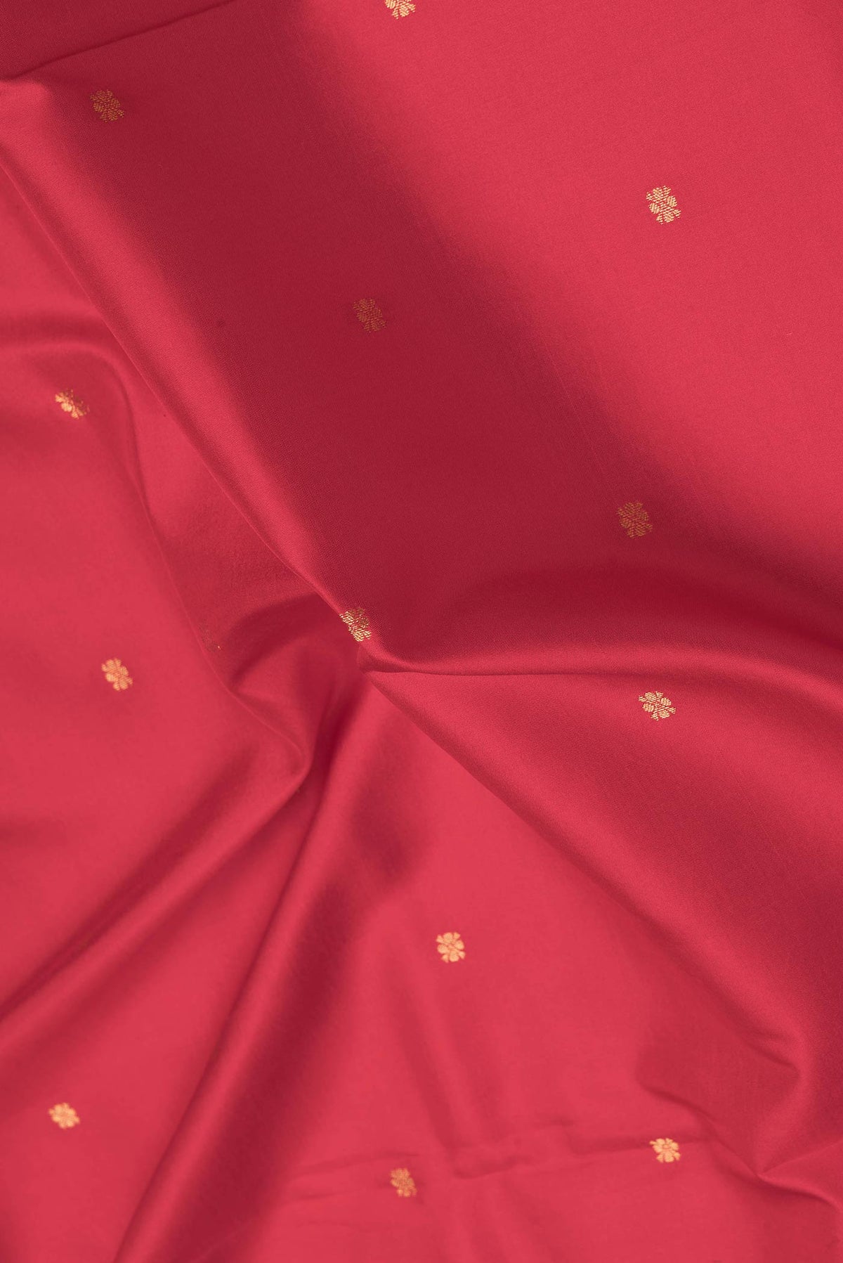Close up of Red Kanchipuram Silk Saree with Zari Butta on the body and Printed Border.  displaying folds